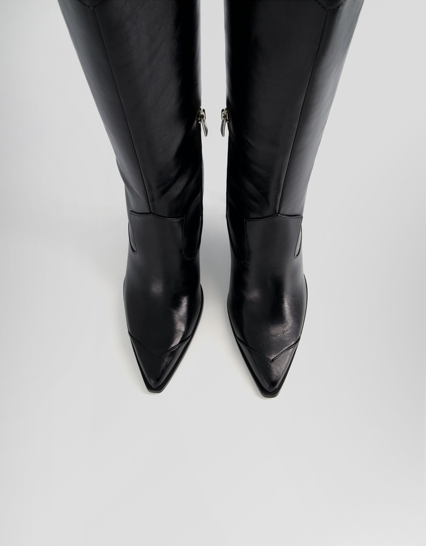 Botas de cowboy com salto agulha e zíper.