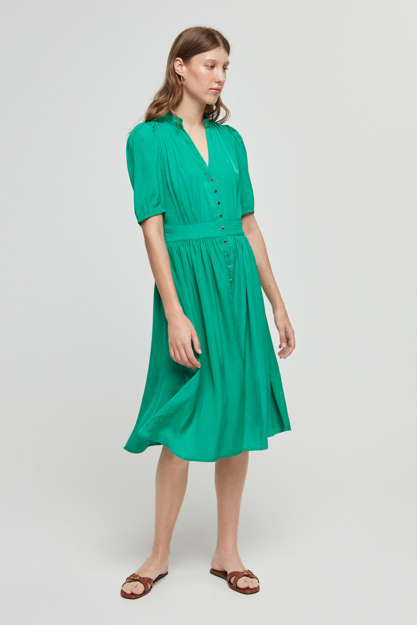 Vestido verde com mangas 3/4 e fechamento por botões.