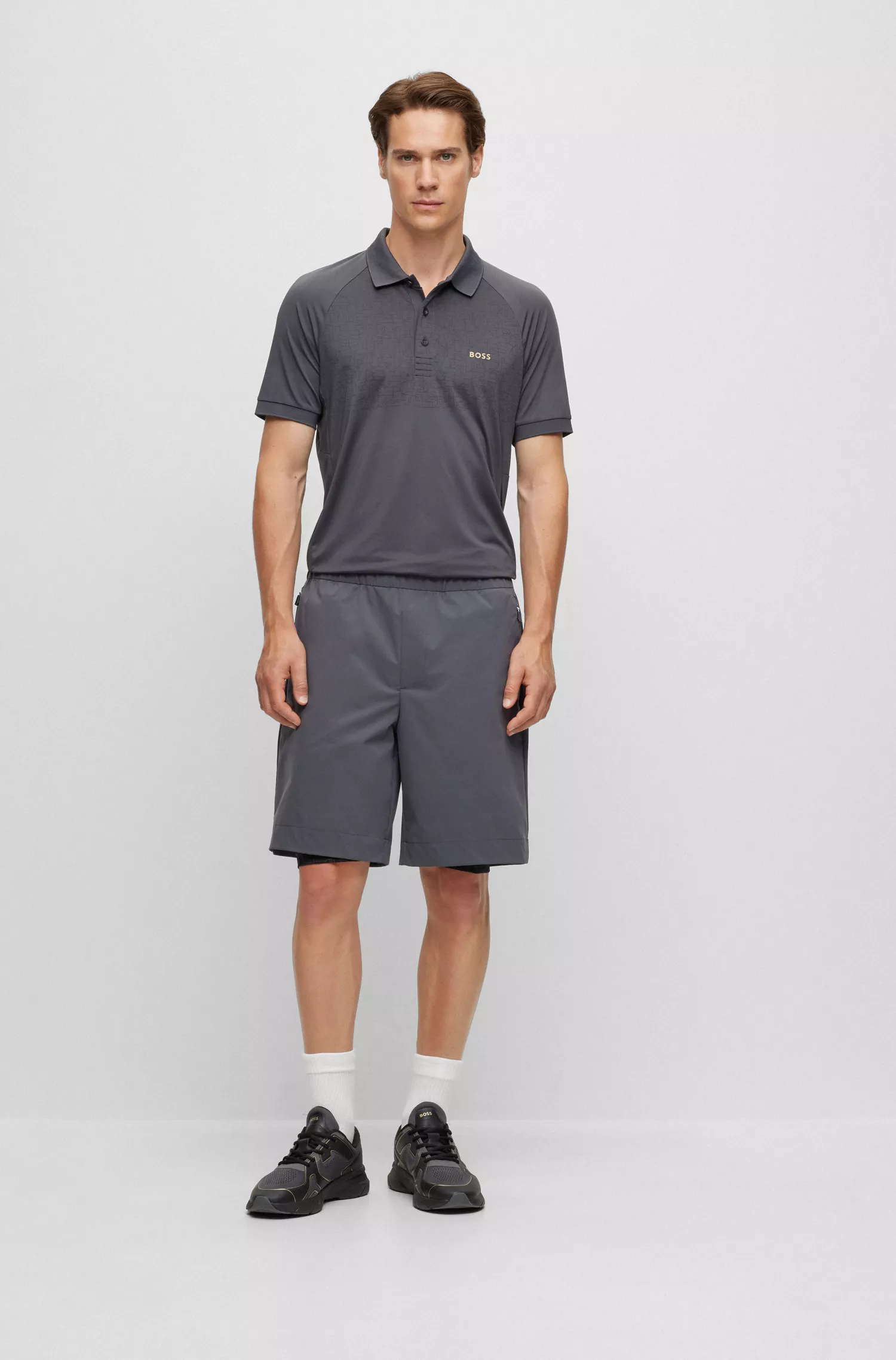 Camisa polo BOSS verde, corte slim, com padrão refletivo decorativo.