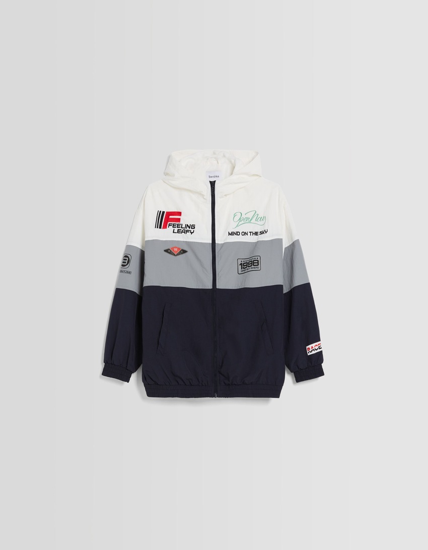 Jaqueta de nylon com capuz e patches.