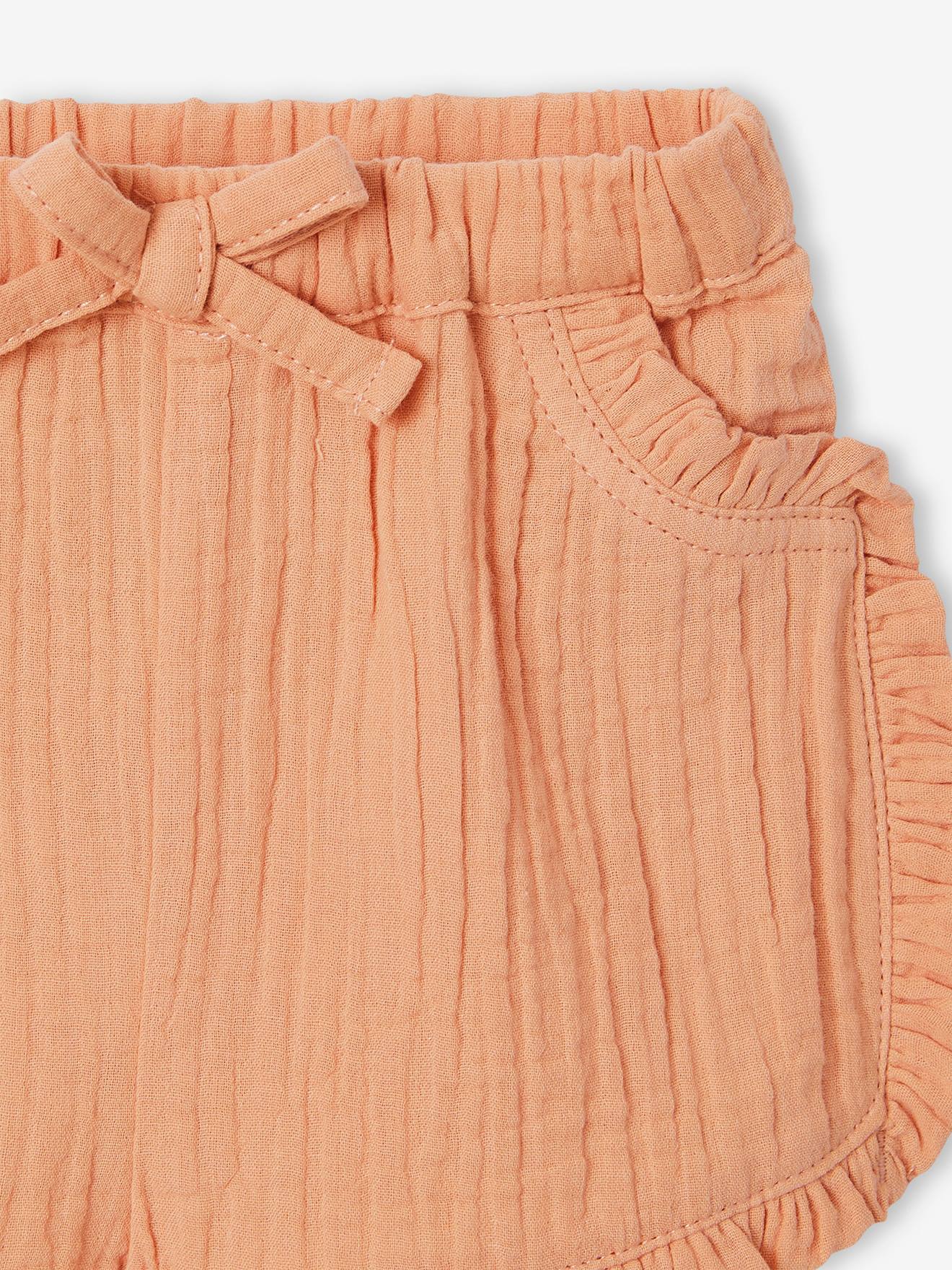 Roupa de bebê: shorts, camiseta listrada e faixa de cabelo verde-acinzentada.