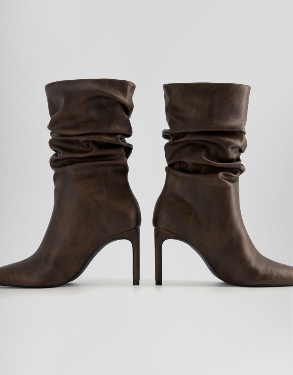 Botas de cano curto com salto agulha e modelagem folgada