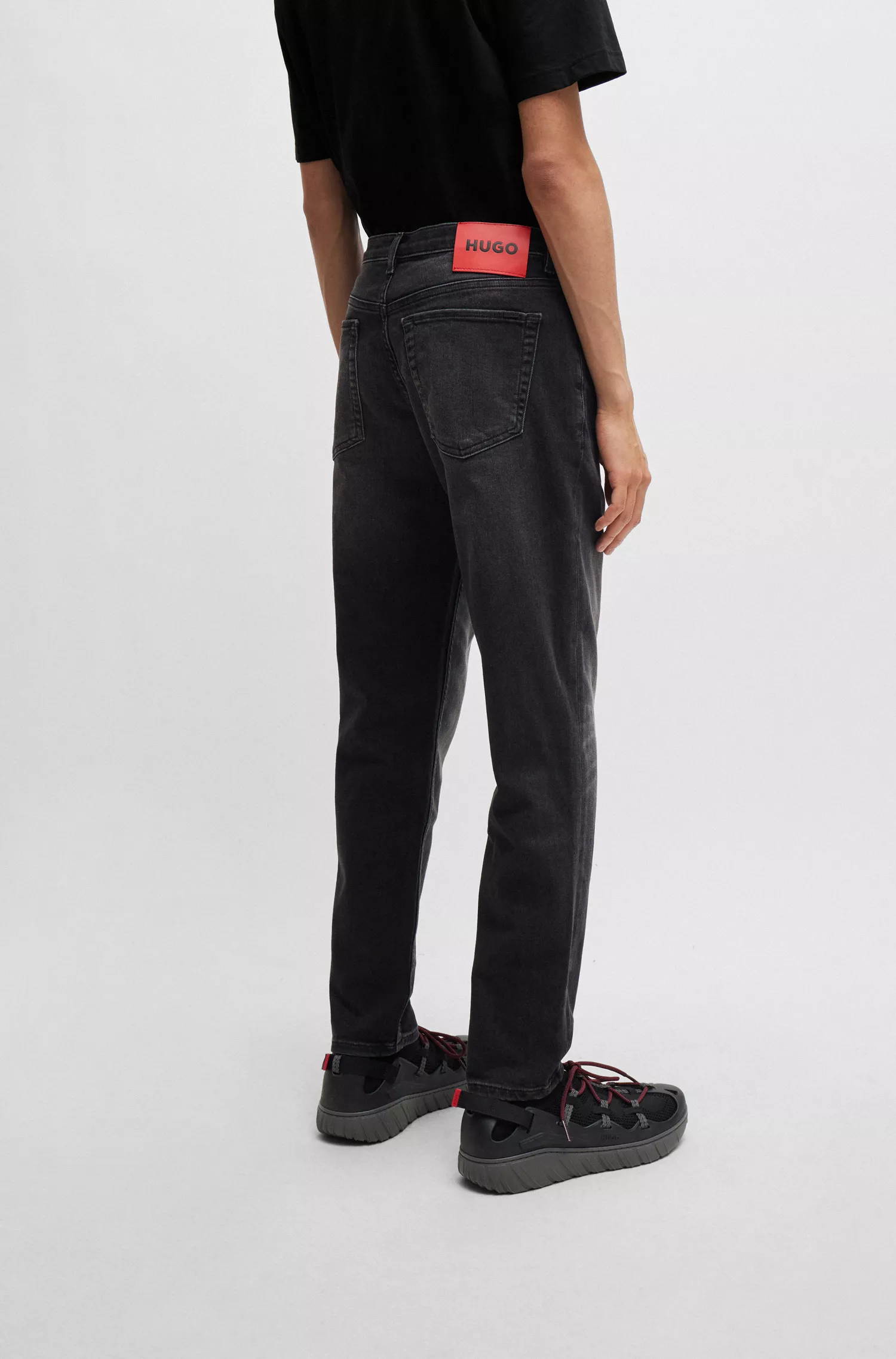 Calça jeans HUGO vermelha, corte afunilado, em denim preto com elasticidade confortável.