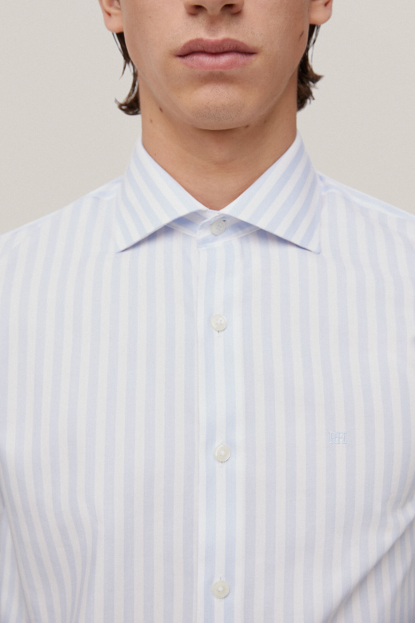 Camisa social listrada, azul, que não precisa passar e é resistente a manchas.