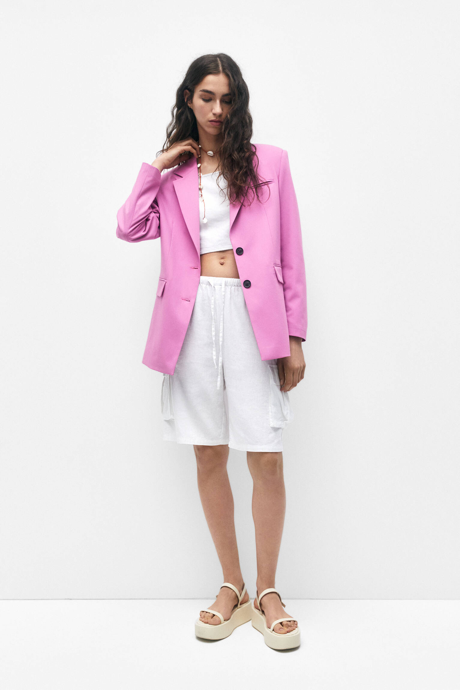 Blazer rosa com abotoamento duplo e detalhe na foto.
