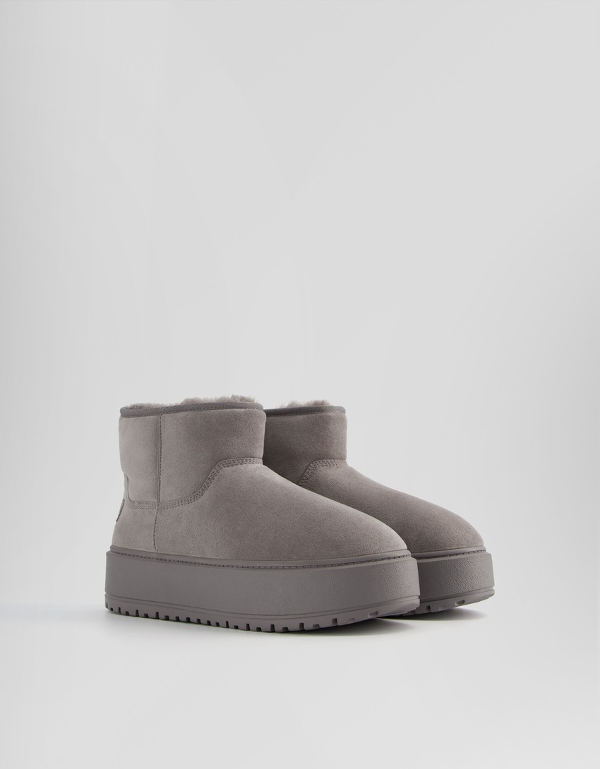 Botas de cano curto com plataforma e forro de pele sintética.