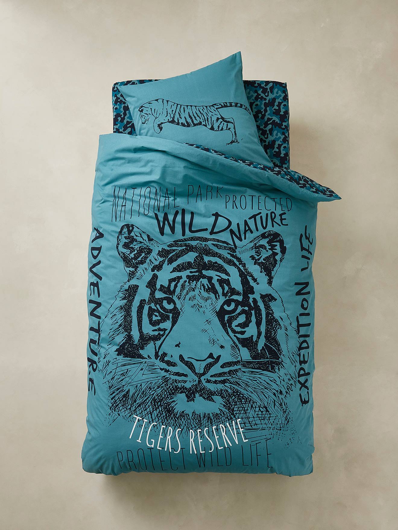 Conjunto de capa de edredom e fronha Tiger em azul médio liso com estampas.