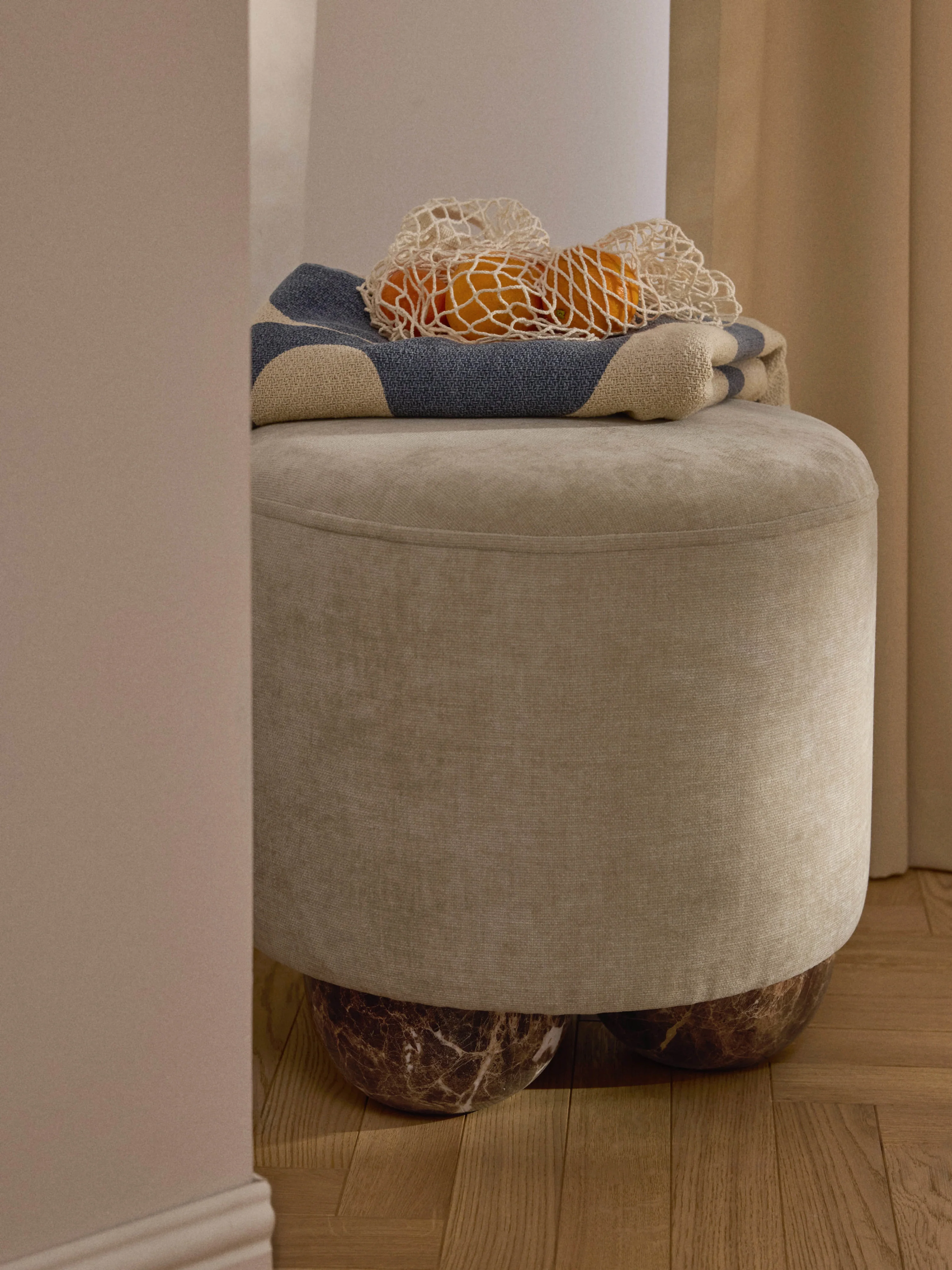Beklede poef Lino met bolpoten met marmerlook