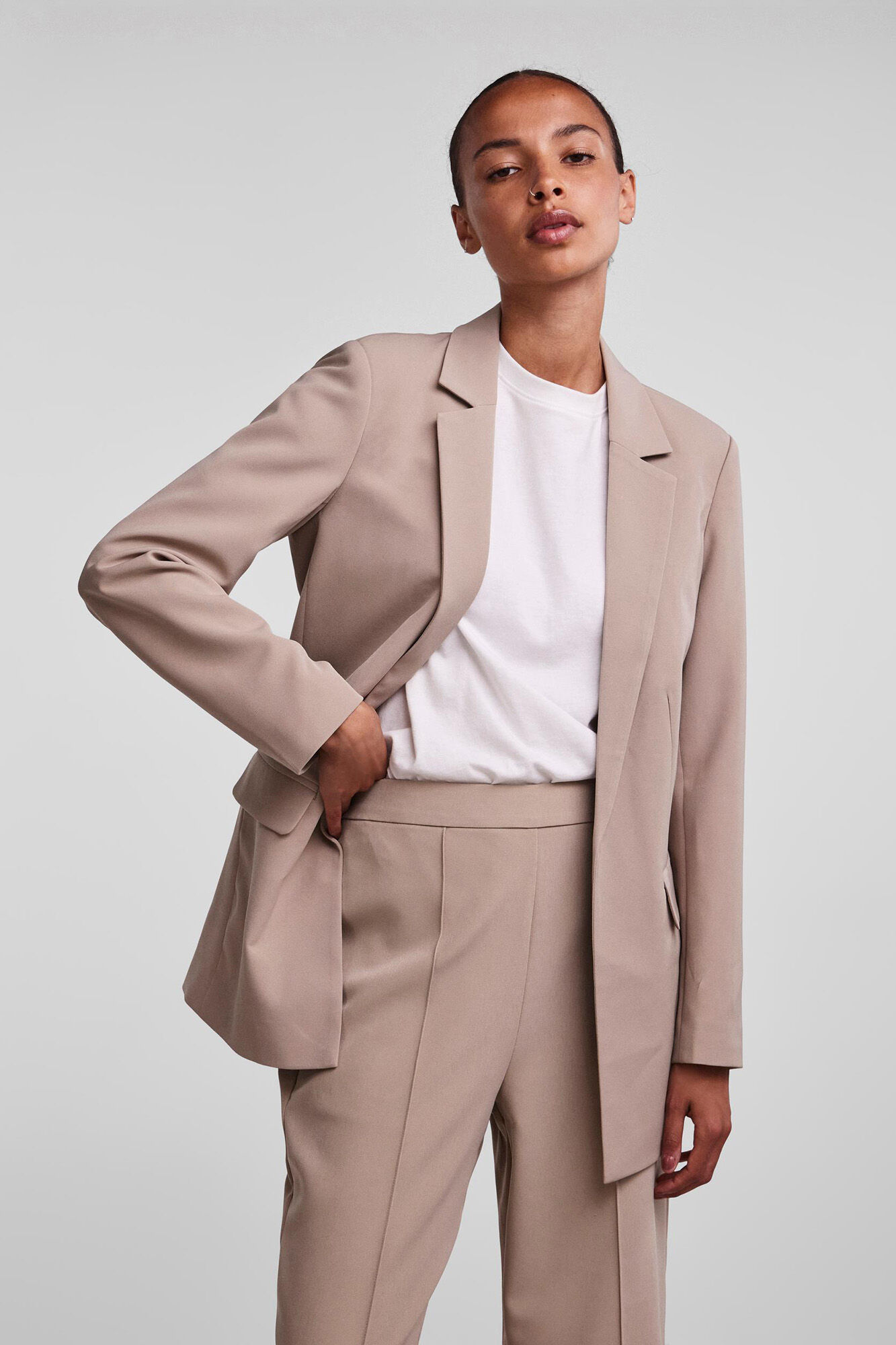 Blazer oversized com mangas compridas, bolsos falsos e lapela no decote.
