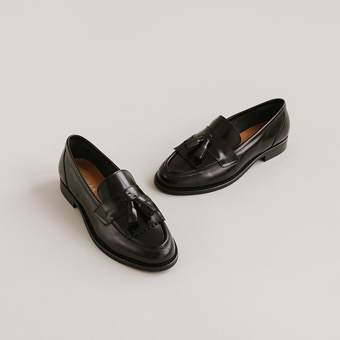 Mocassins à talons plats et pompons  en cuir noir