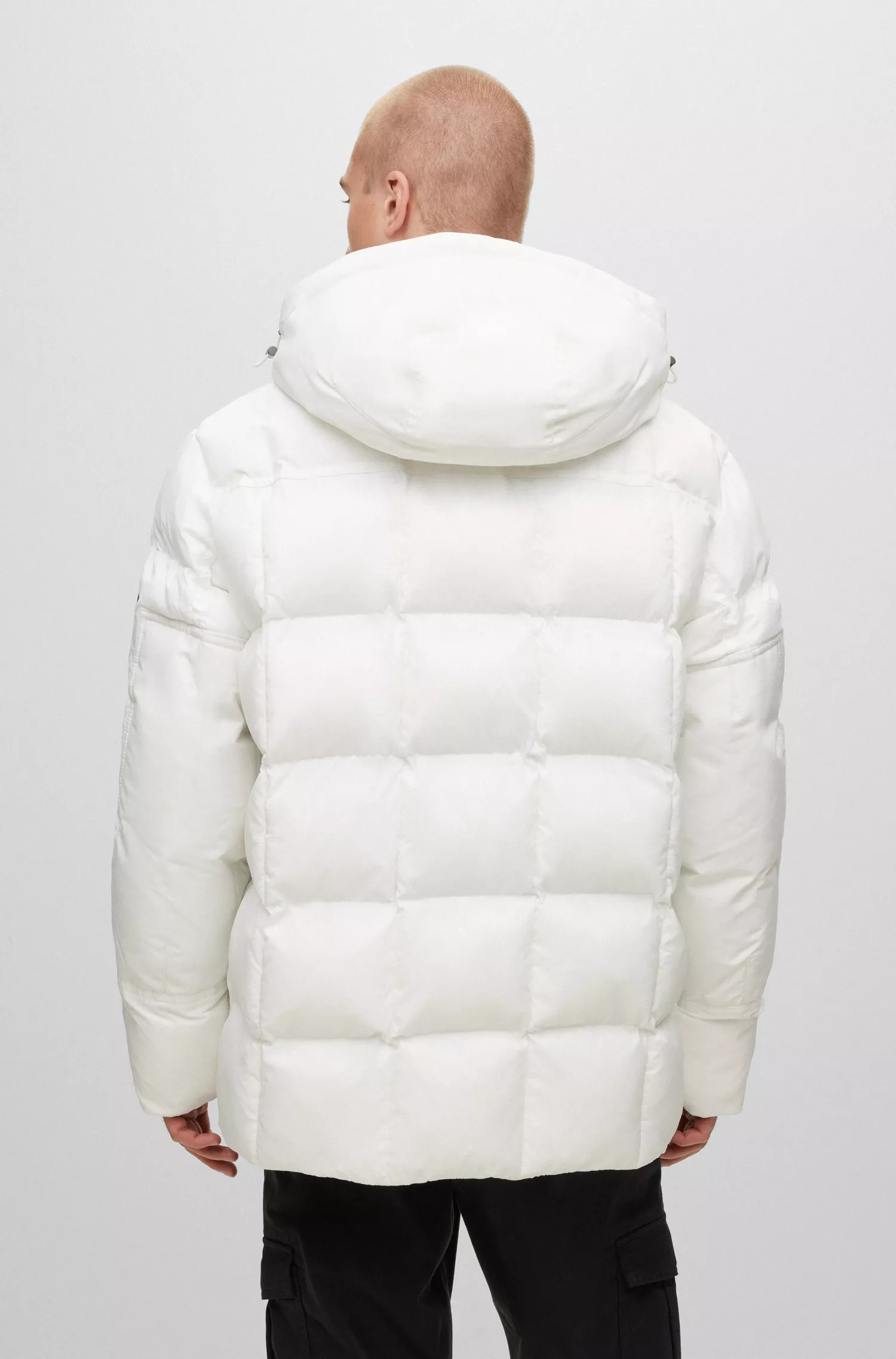 Jaqueta parka BOSS laranja, modelagem relaxada e repelente à água, com emblema da marca.