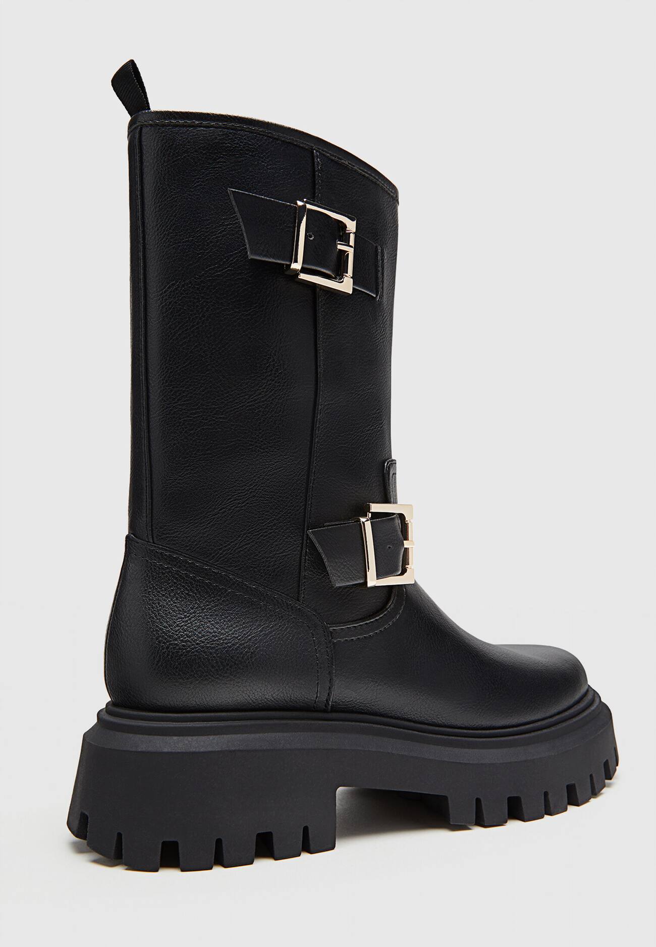 Botas pretas de cano curto sem salto e com fivelas.