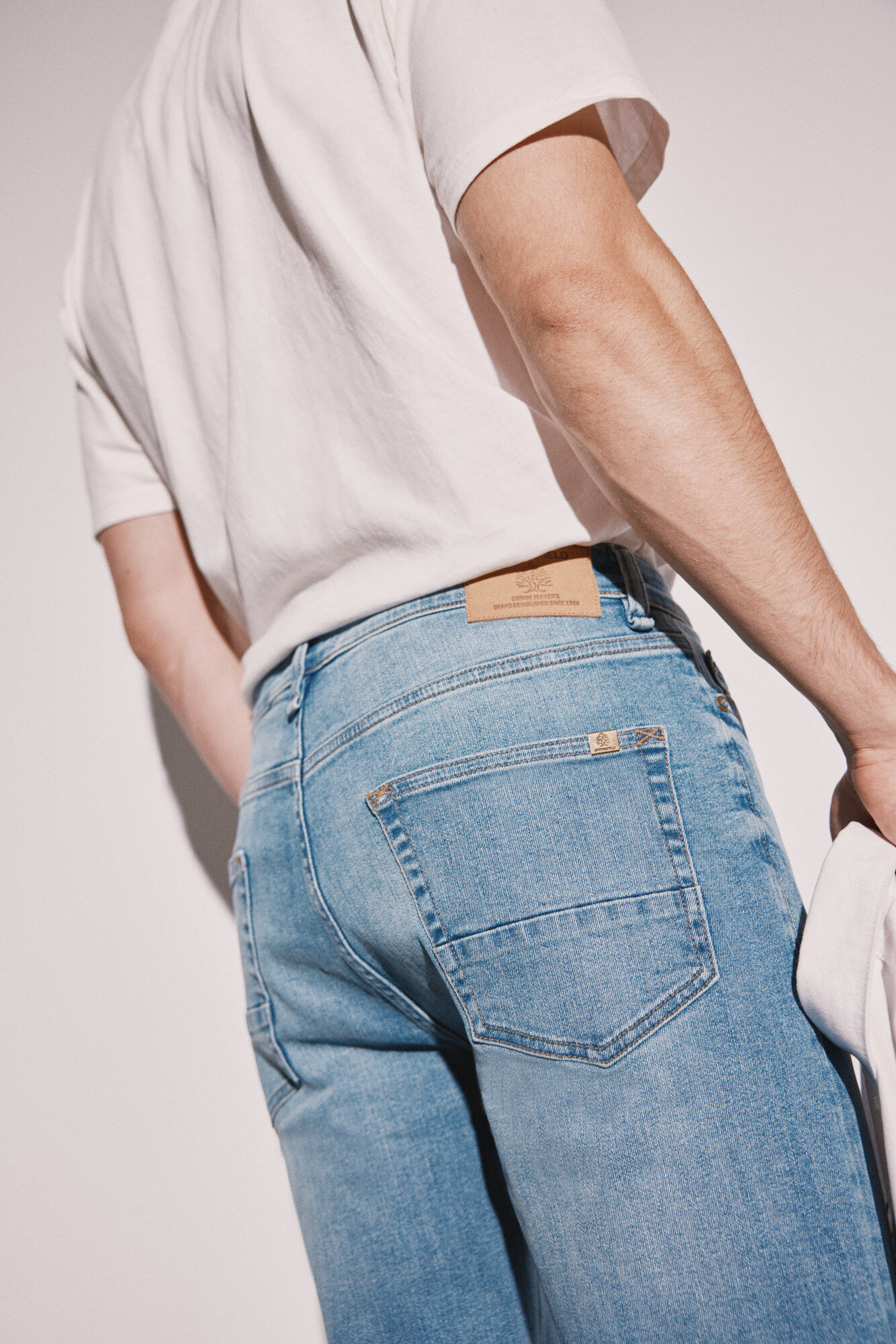 Calça jeans slim, lavagem média, levemente suja.