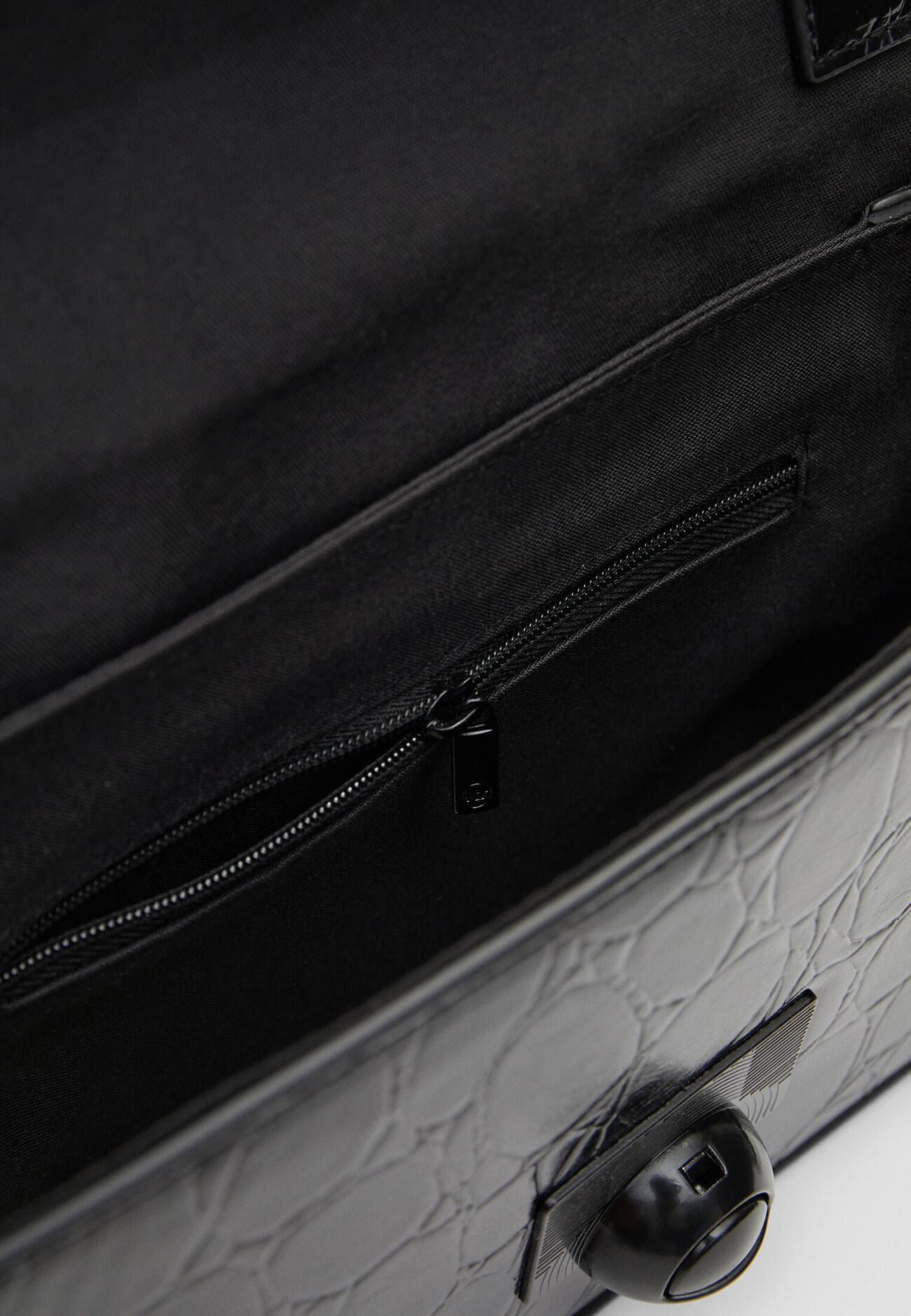 Bolsa transversal com estampa de crocodilo e fecho.