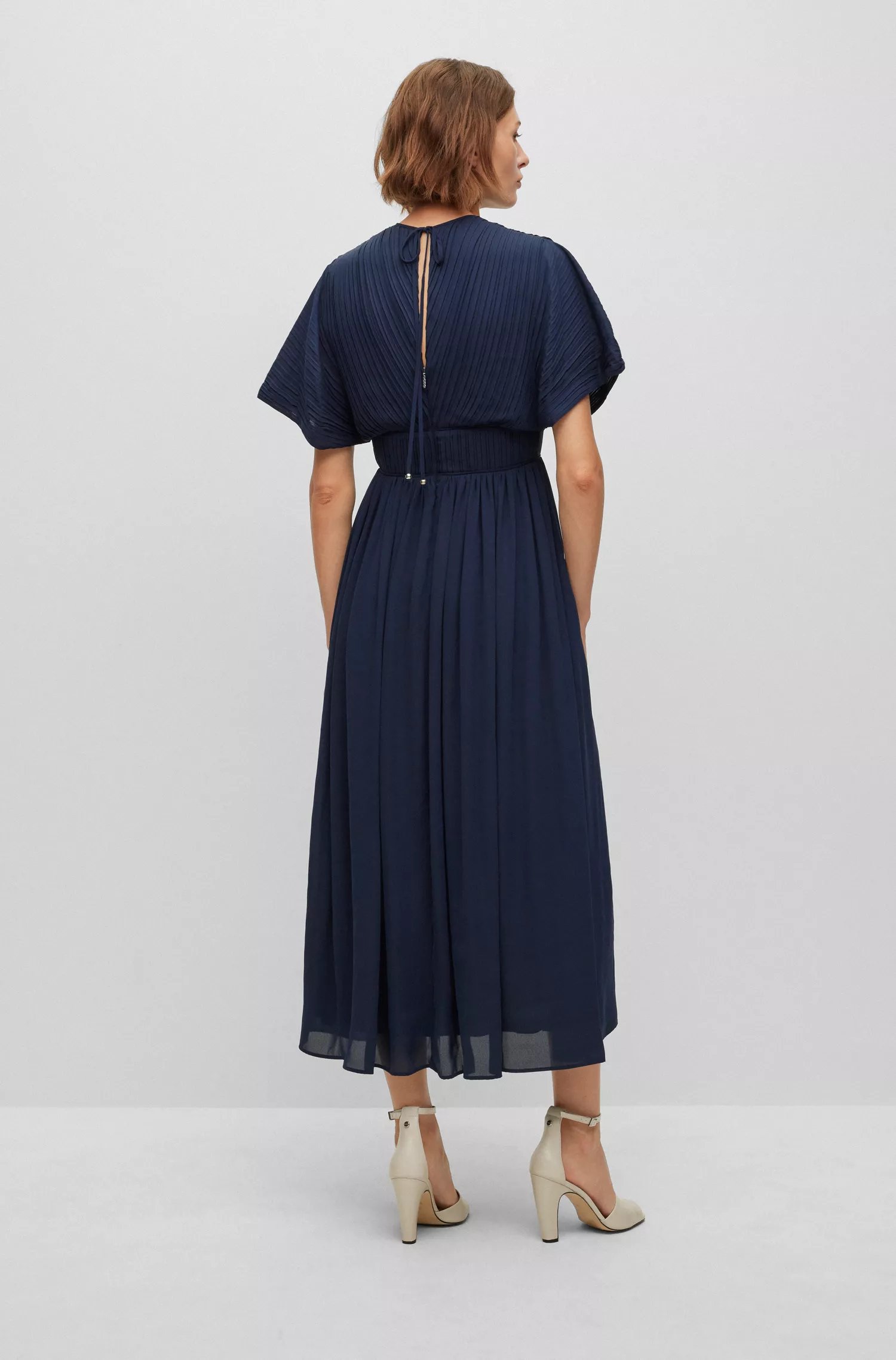 Vestido preto justo da BOSS com amarração nas costas e decote em formato de gota.