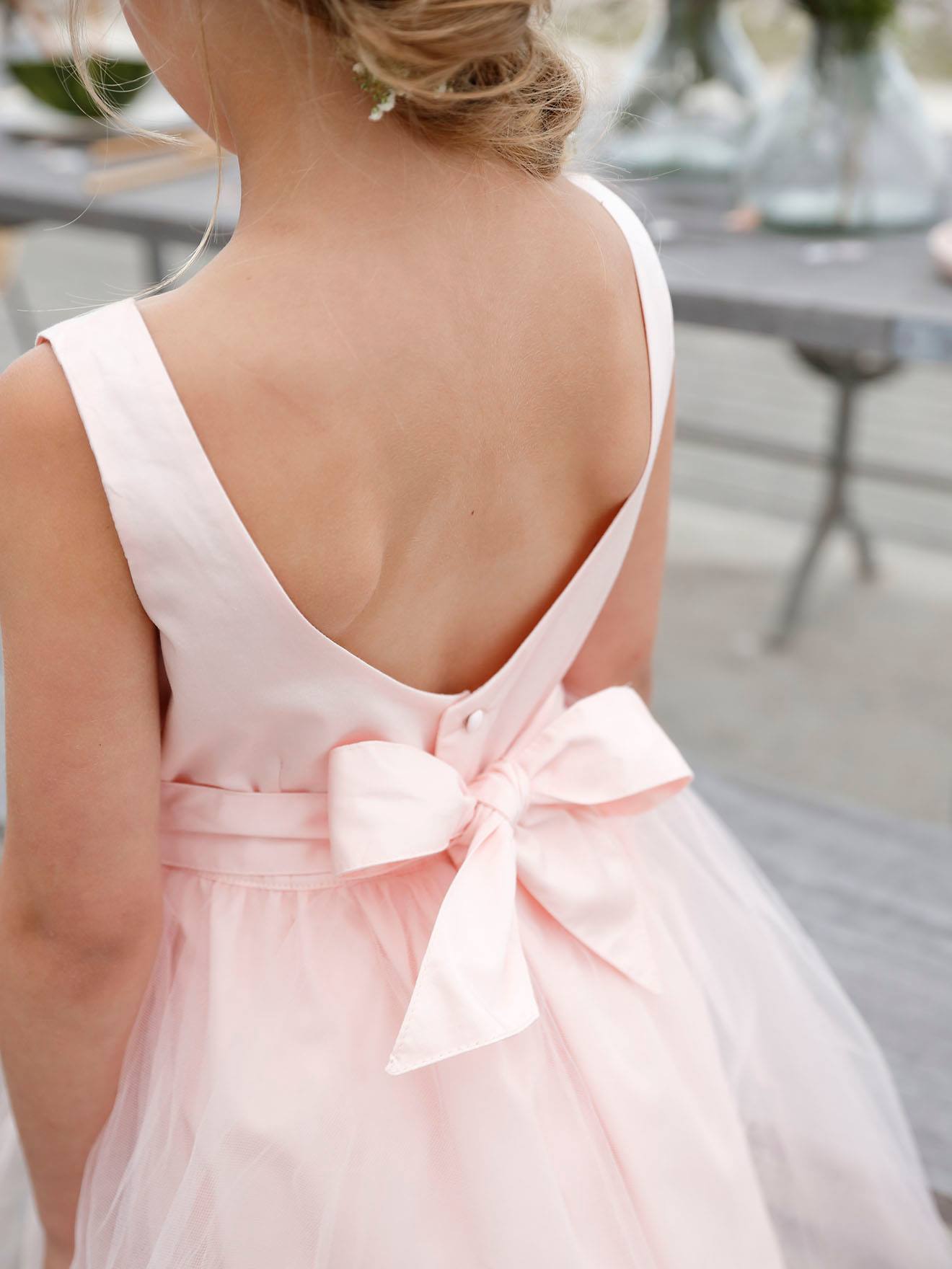 Vestido formal de cetim e musselina bege para menina, com maquiagem.