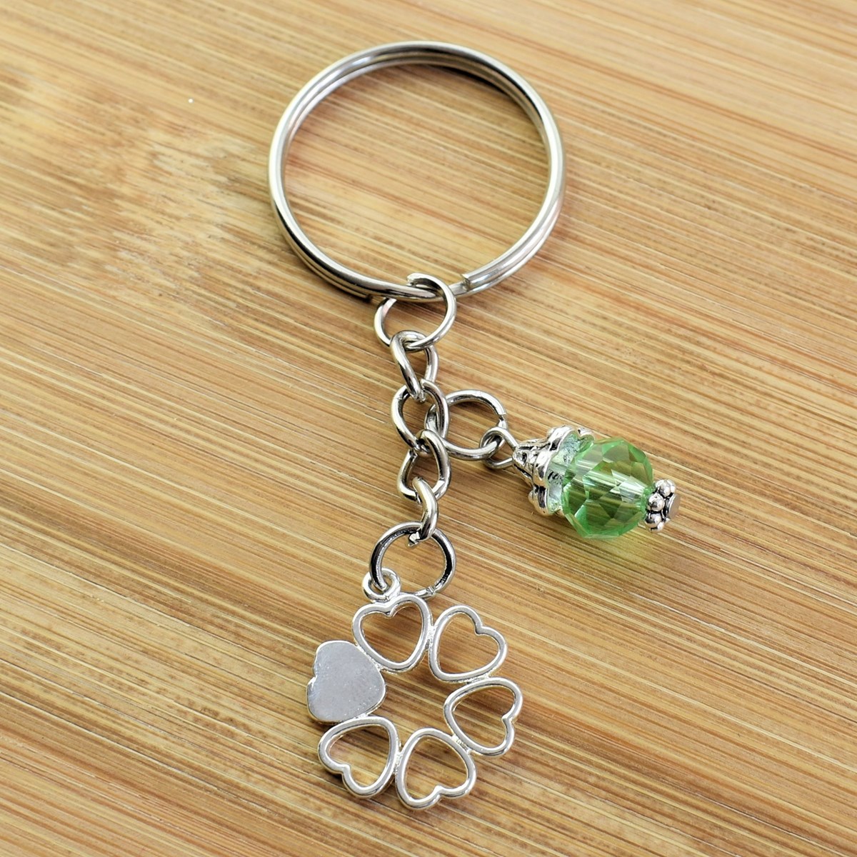 Porte-clés cercle de coeurs argenté et perle à facettes verte