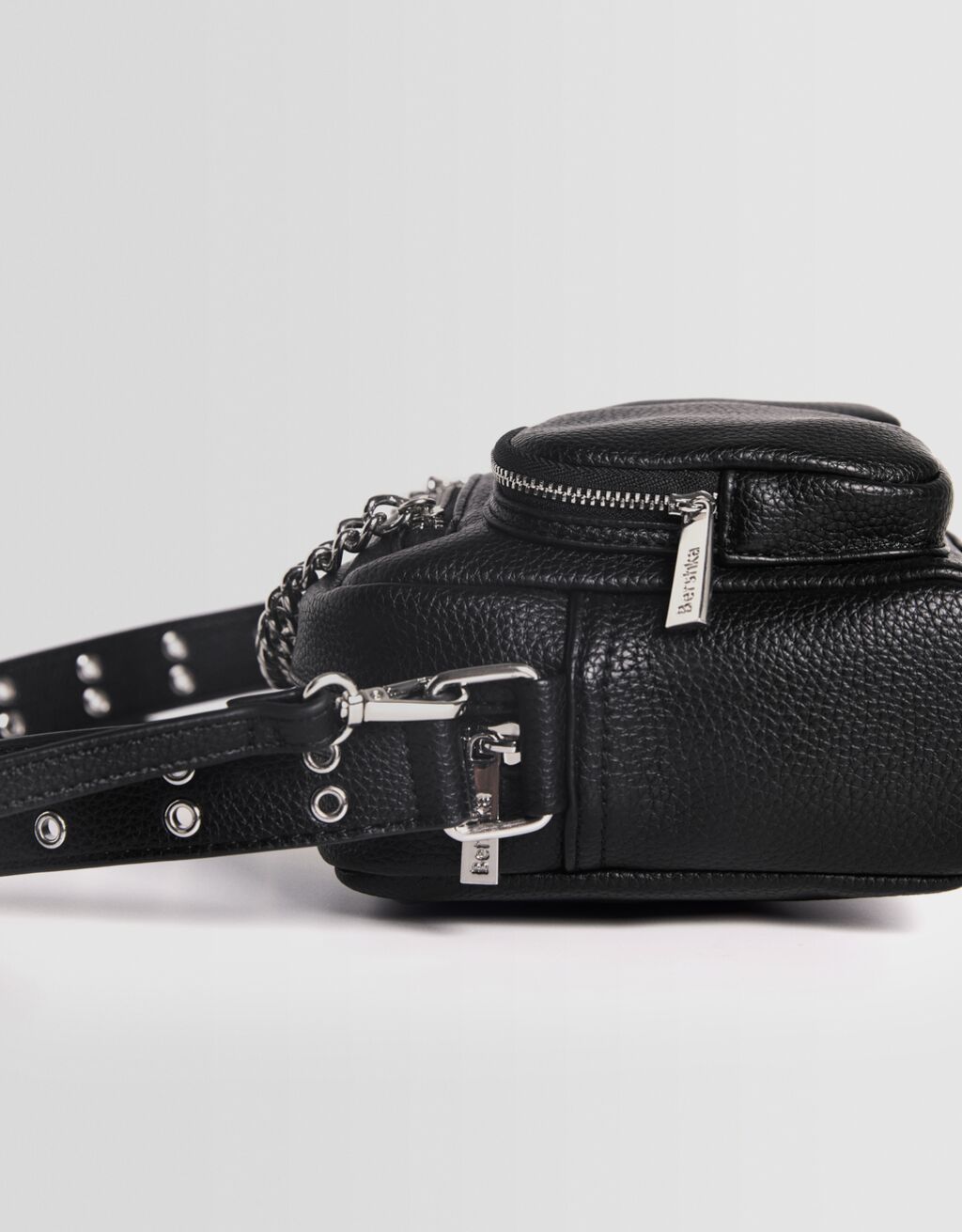 Bolsa transversal multifuncional com corrente e bolsos.