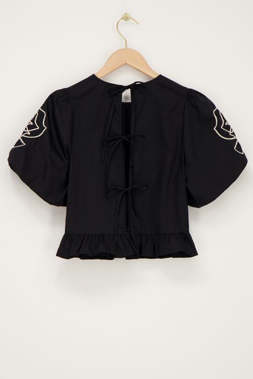 Zwarte blouse met bloemen detail en strikjes aan achterzijde