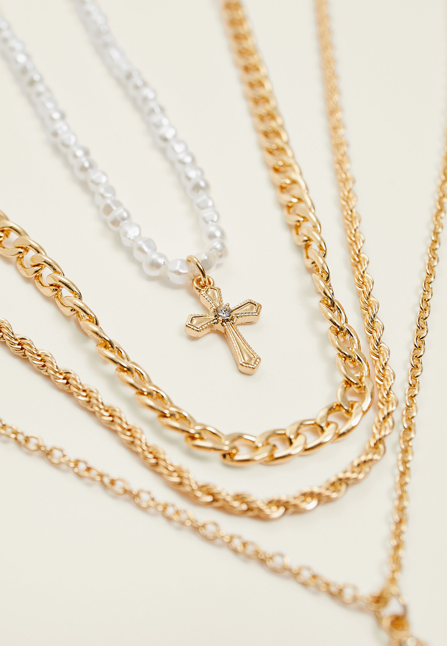 Conjunto de 4 colares com pingente de cruz e pérolas artificiais.