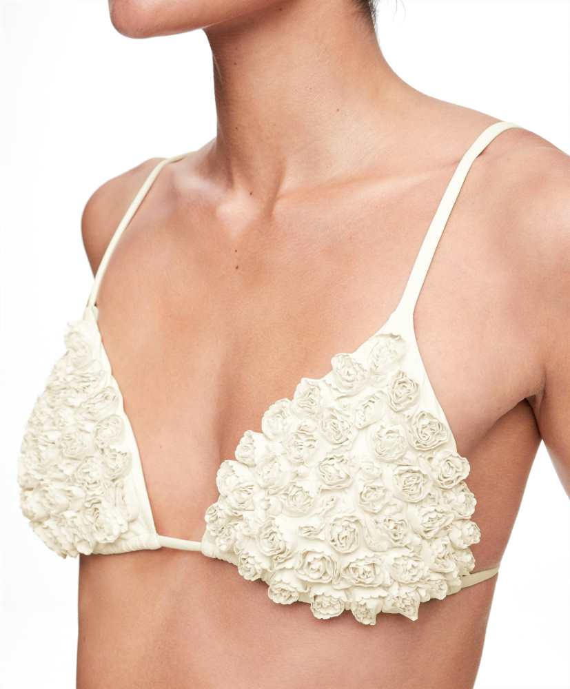 Top de biquíni triangular com flores aplicadas.