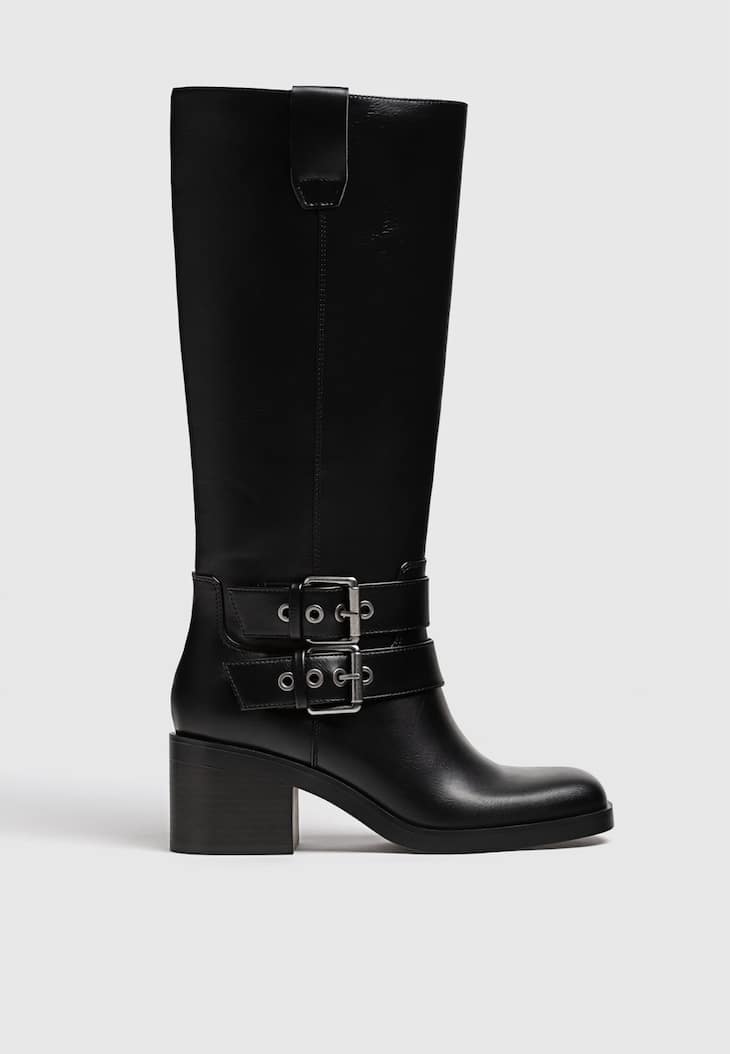 Botas pretas de motociclista com salto e fivelas.