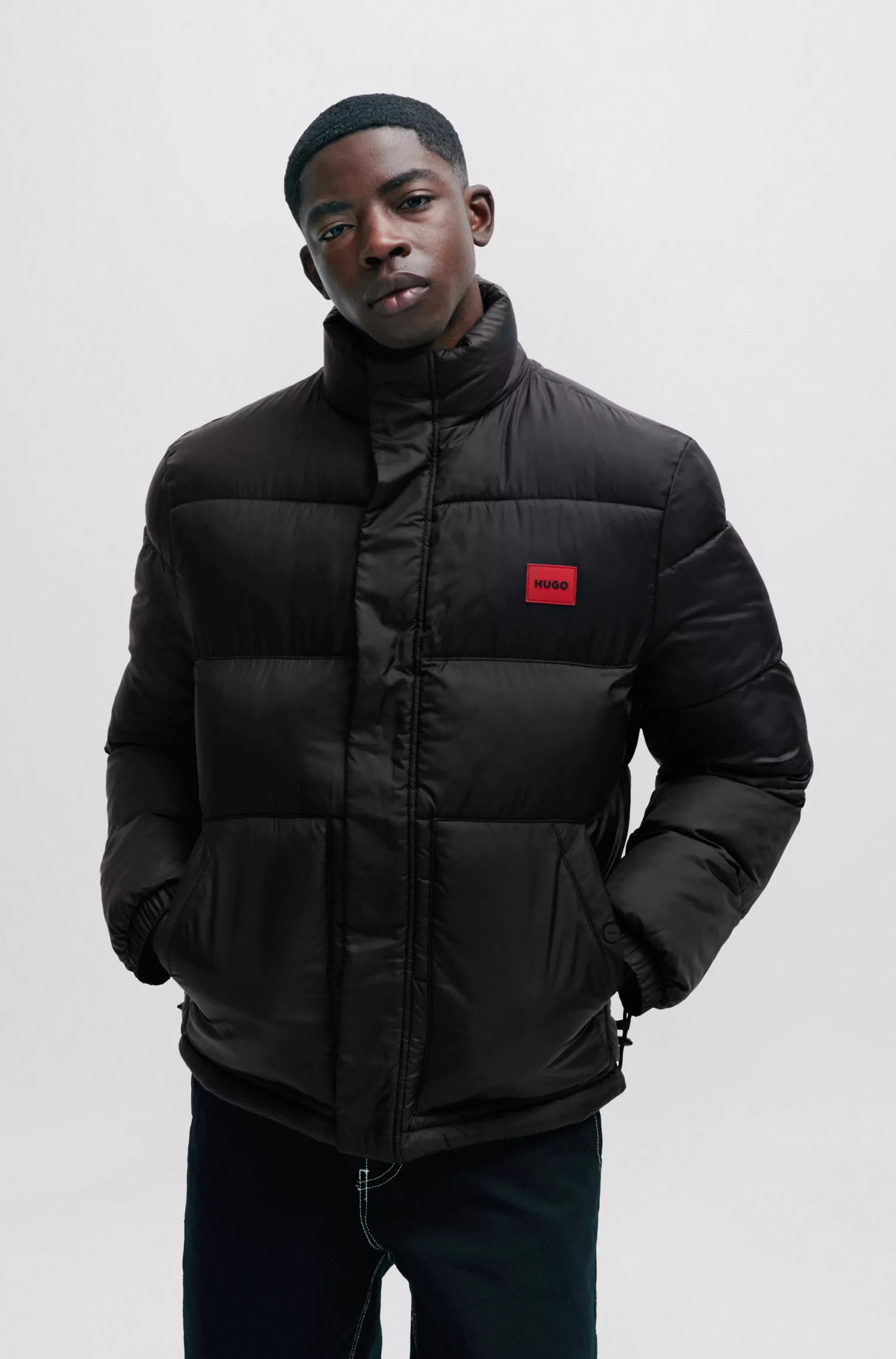 Jaqueta puffer HUGO vermelha, impermeável, com emblema vermelho da marca.
