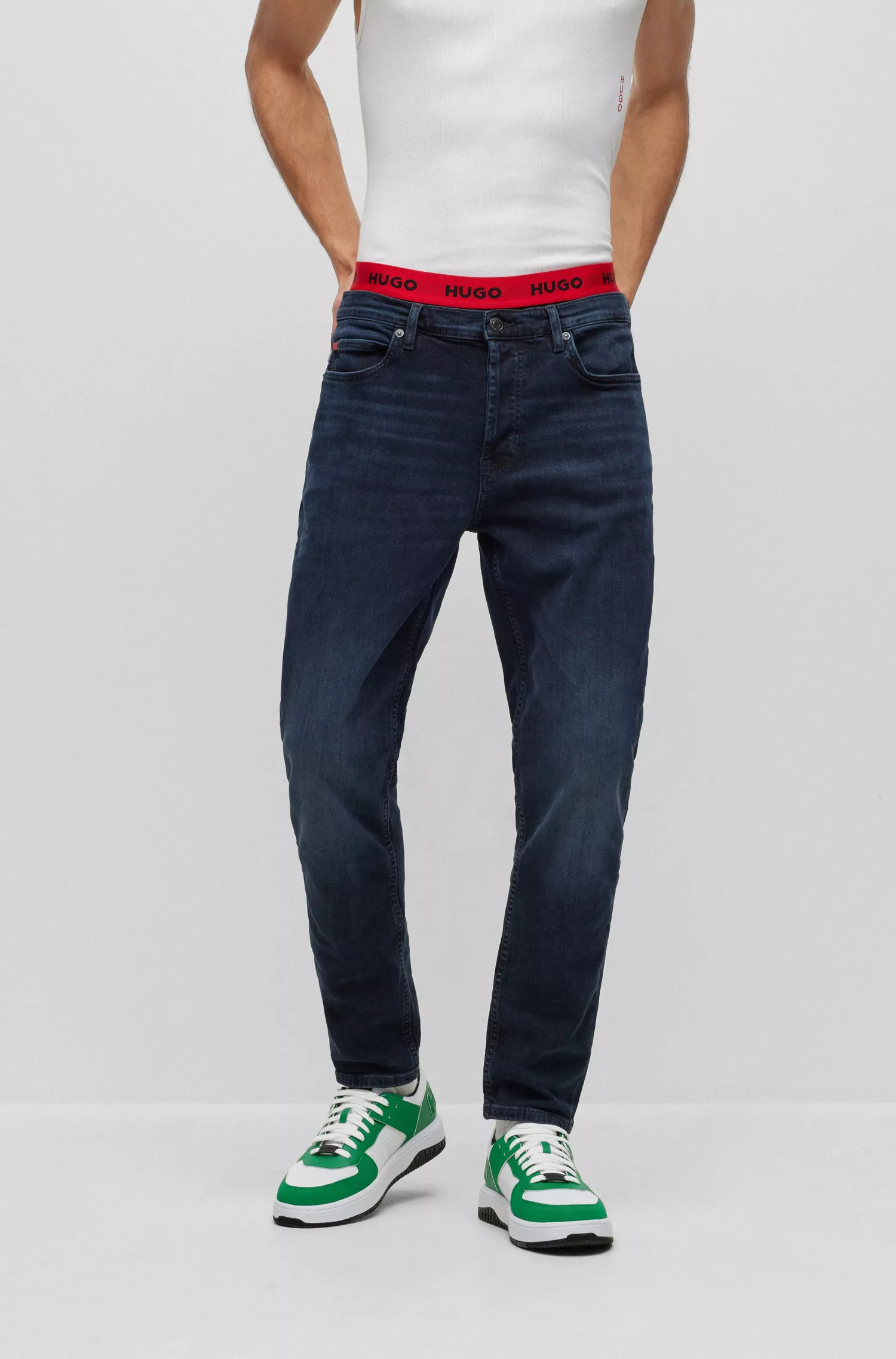 Calça jeans HUGO vermelha, corte afunilado, em denim azul-escuro.