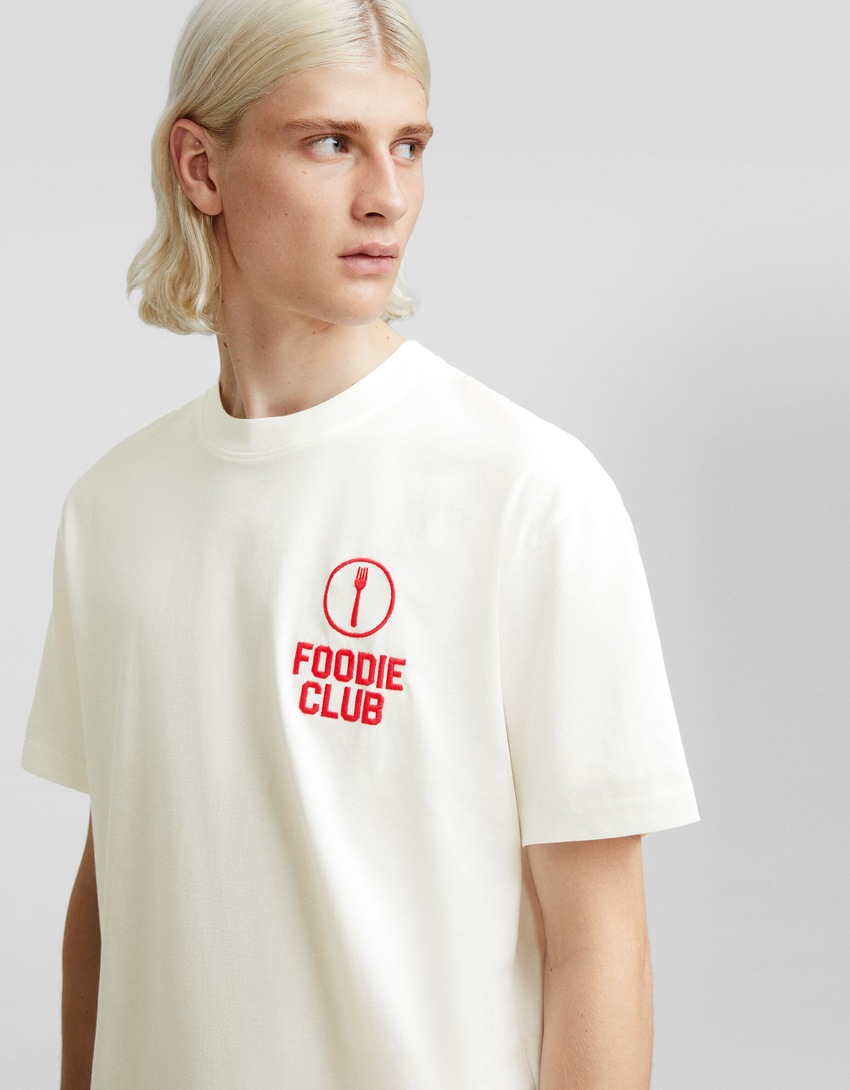 Camiseta de manga curta com modelagem quadrada e detalhes bordados.