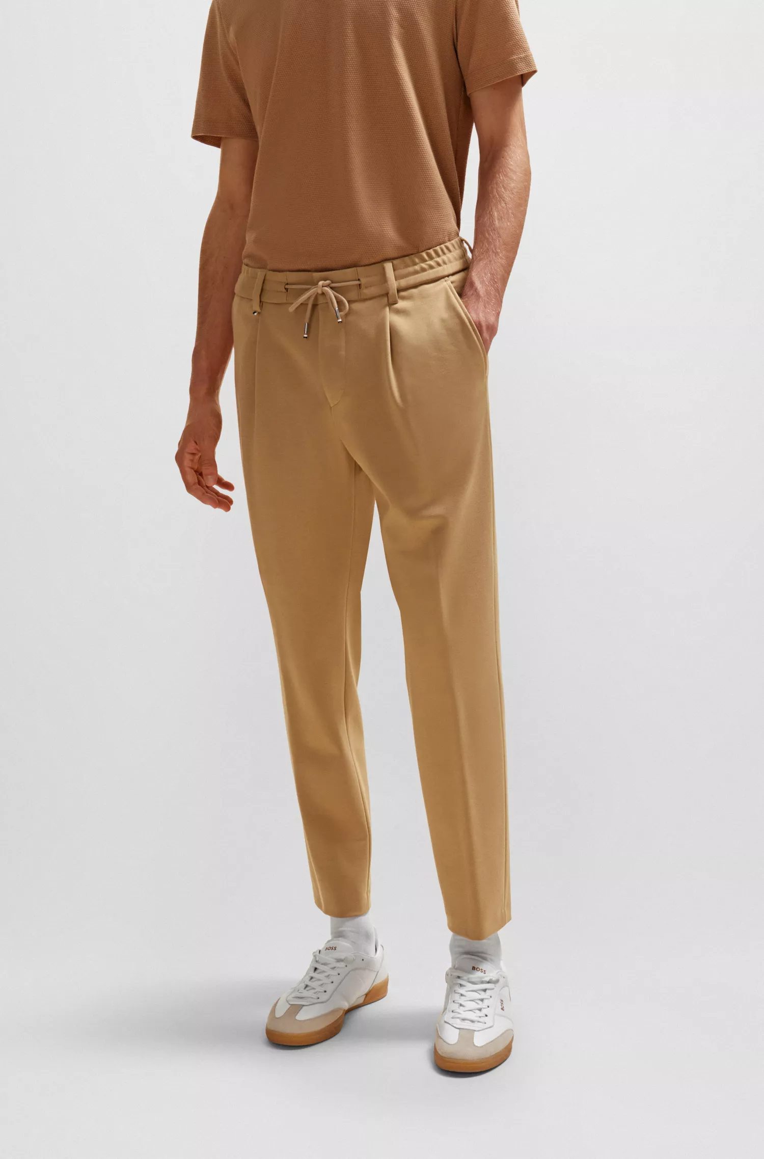 Calça BOSS preta, modelagem relaxada com cordão, em tecido bi-elástico.