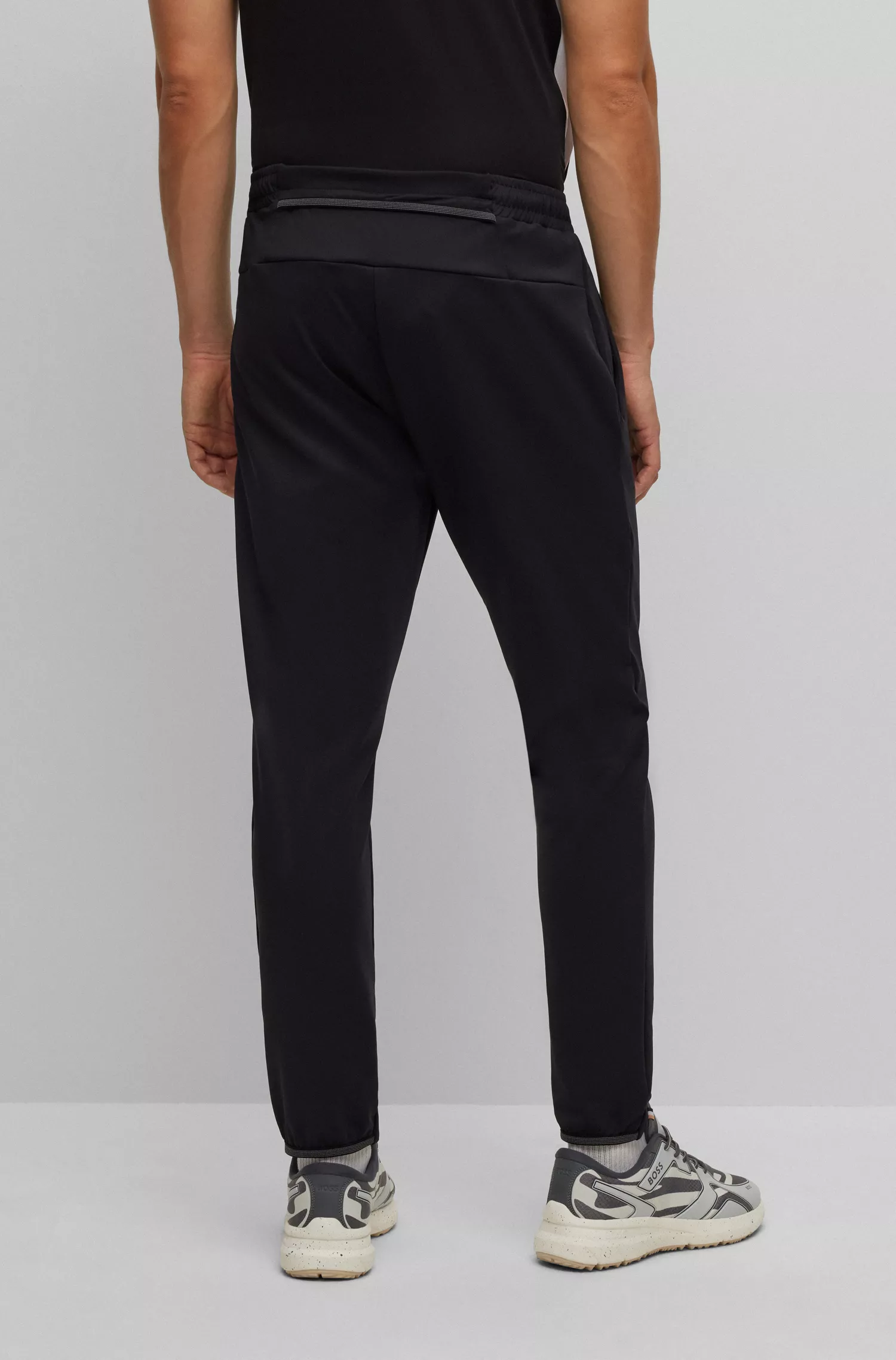 Calça de fato de treino BOSS verde com punhos, em tecido elástico para atividades físicas.