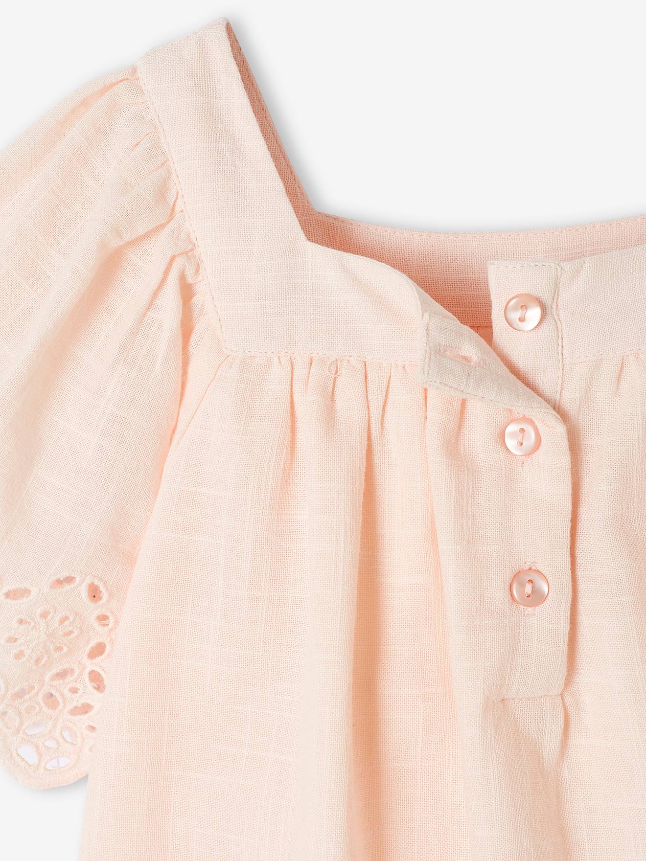 Vestido infantil rosa claro adornado com bordados ingleses e mangas borboleta.