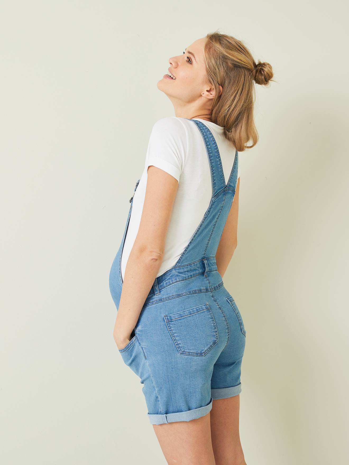 jardineira de maternidade em jeans azul de lavagem média