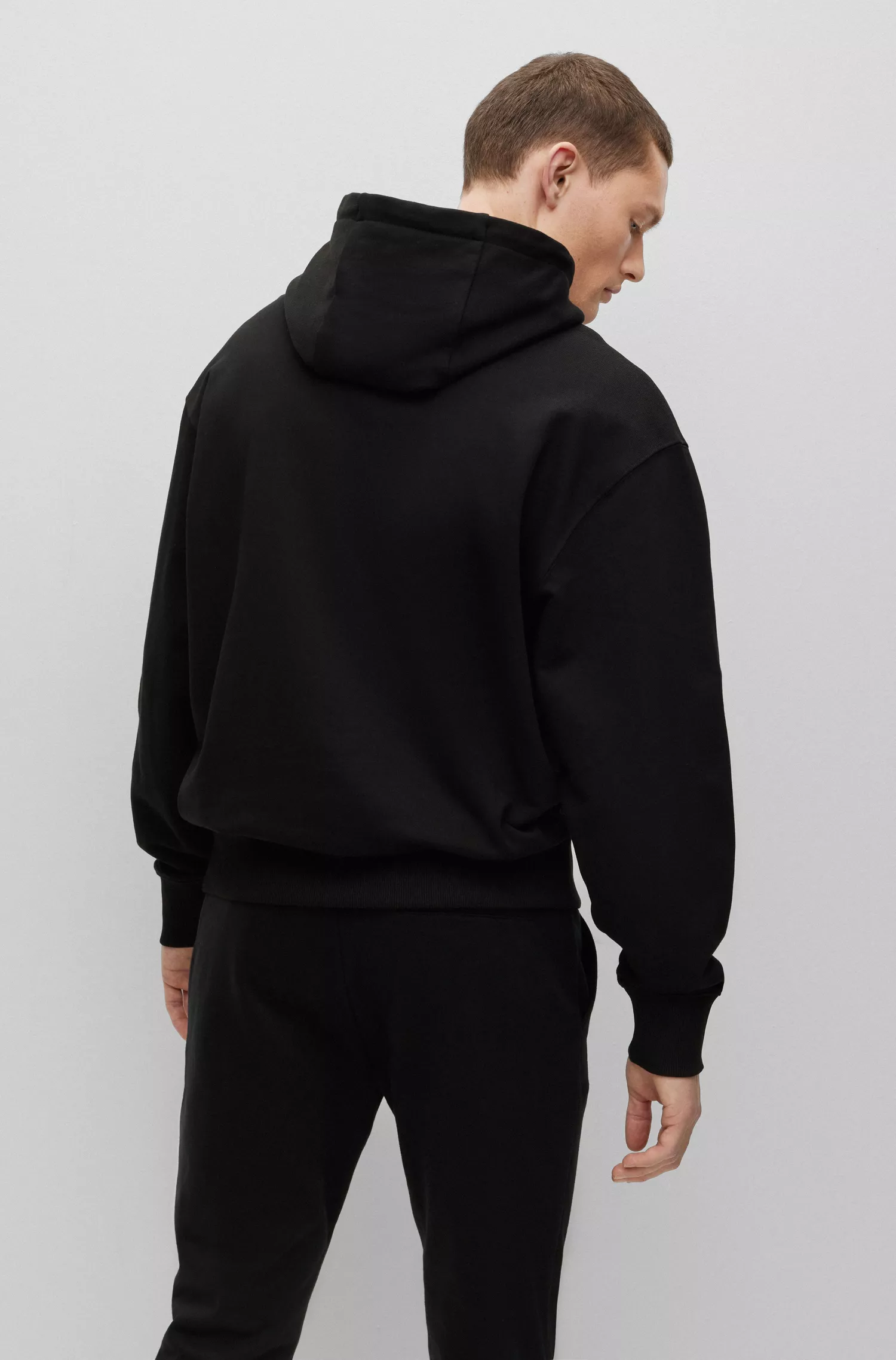 Moletom BOSS preto, modelagem oversized, em algodão felpudo com logo contrastante.
