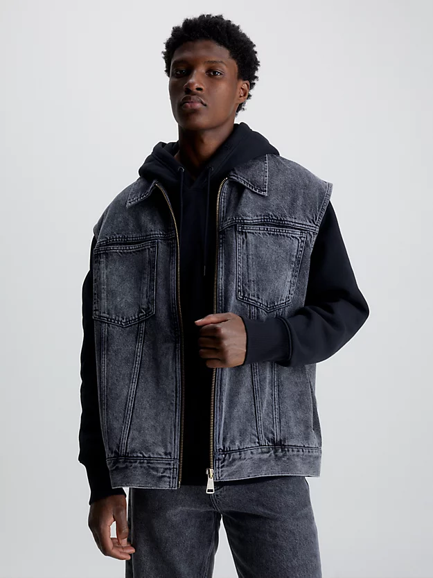 Colete jeans oversized com zíper frontal completo.