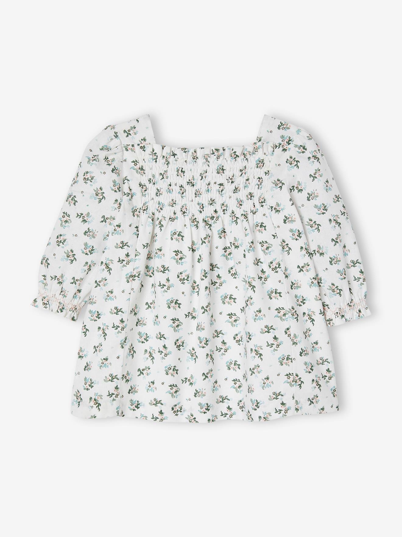 Vestido floral branco para bebê com detalhes franzidos.