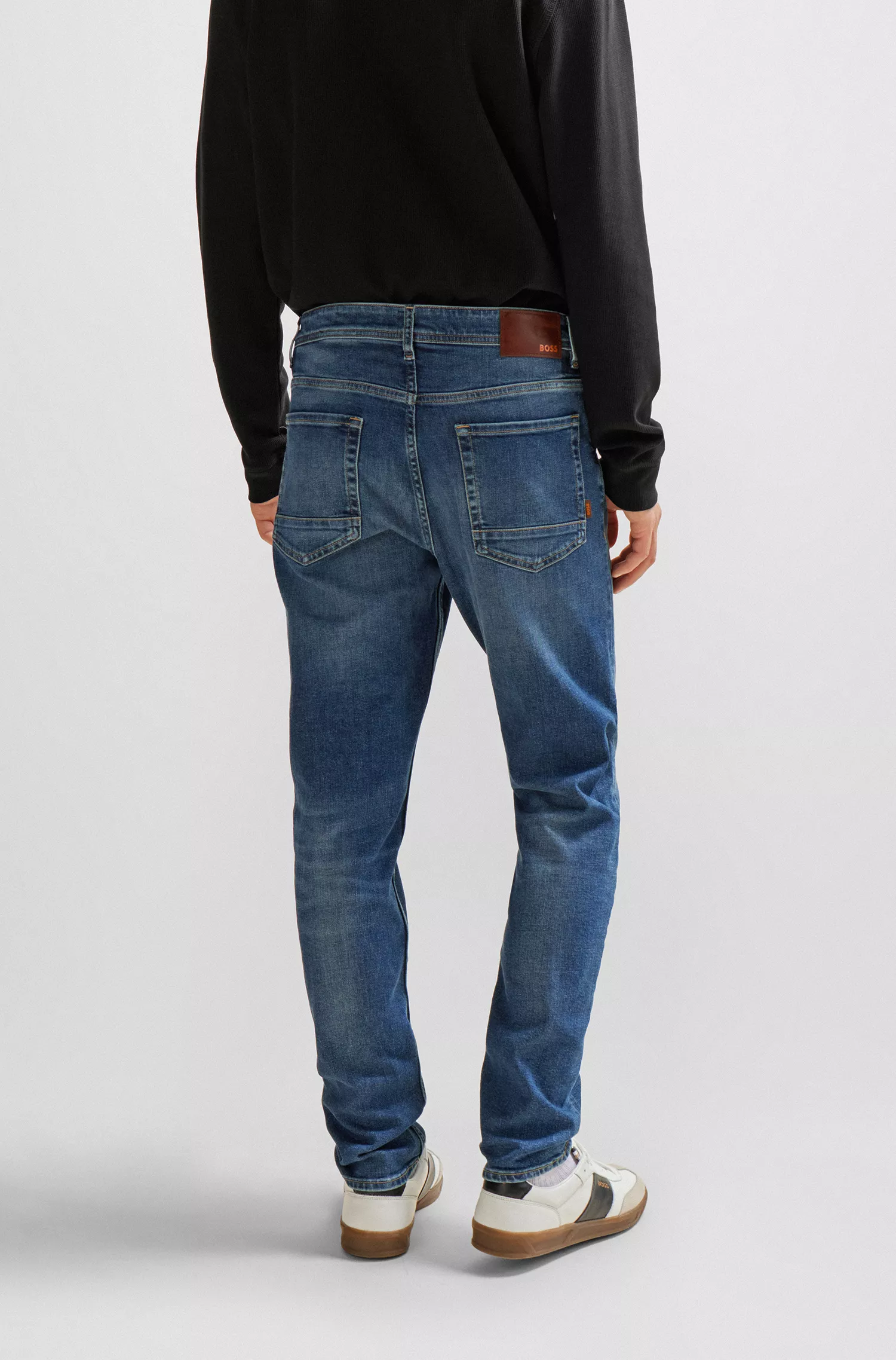 Calça jeans BOSS laranja, corte afunilado, em denim azul com elasticidade confortável.