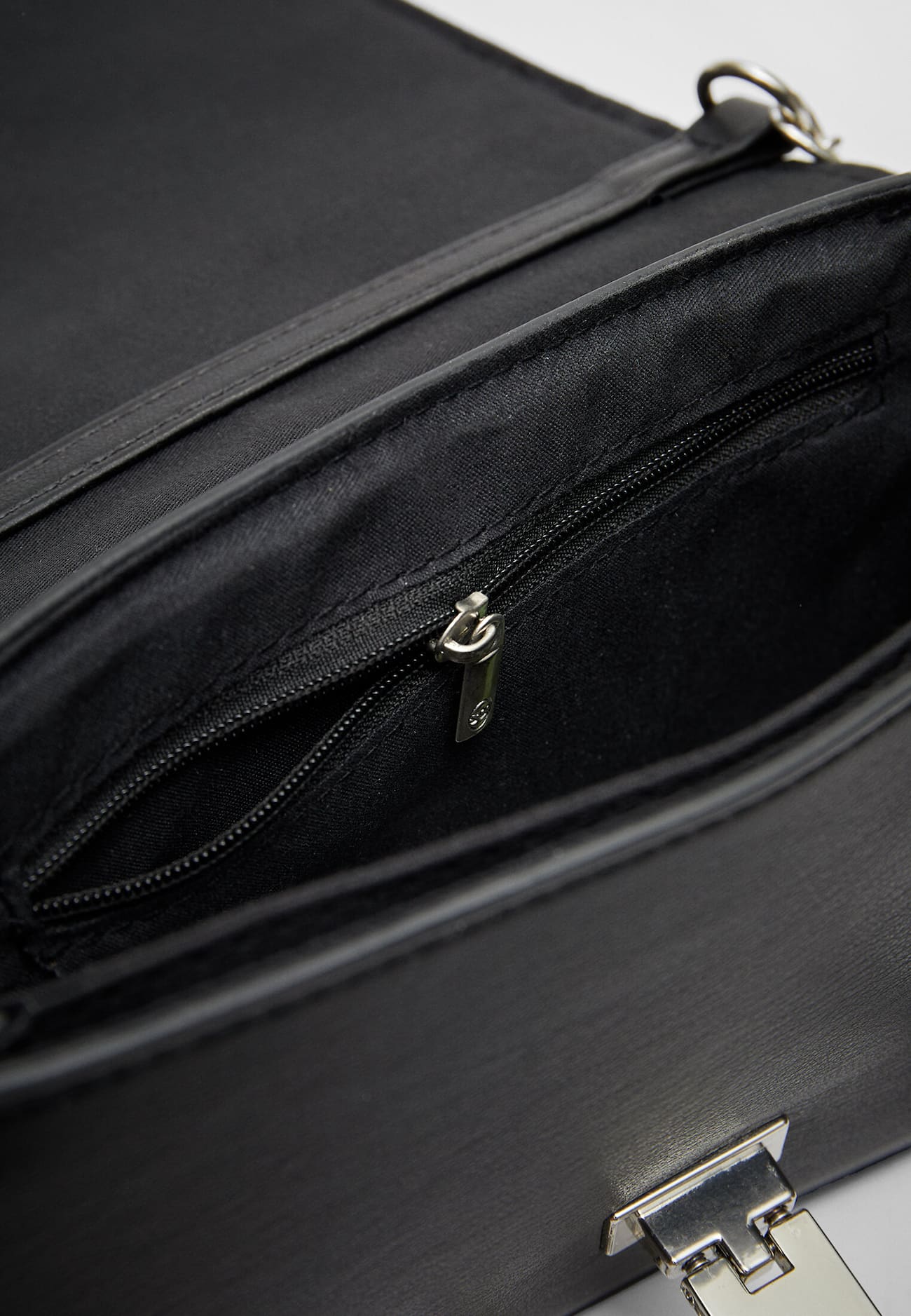Bolsa transversal com detalhes em metal.