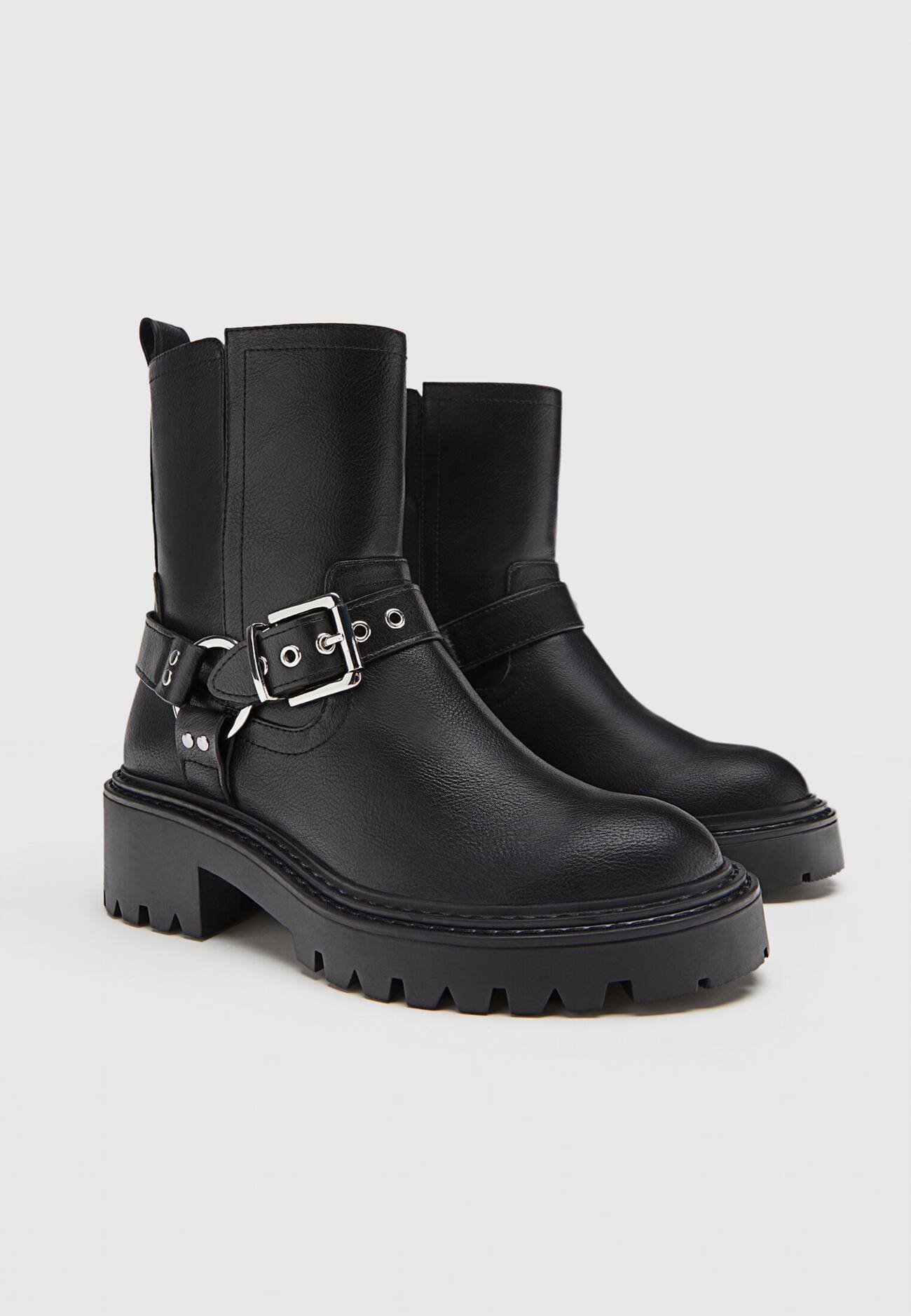 Botas de cano curto estilo motociclista, sem salto, com detalhes de fivela.