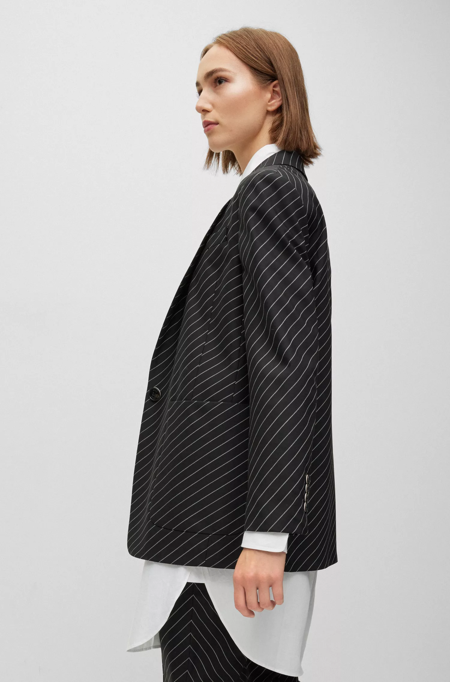 Jaqueta BOSS preta de modelagem oversized em lã elástica listrada.