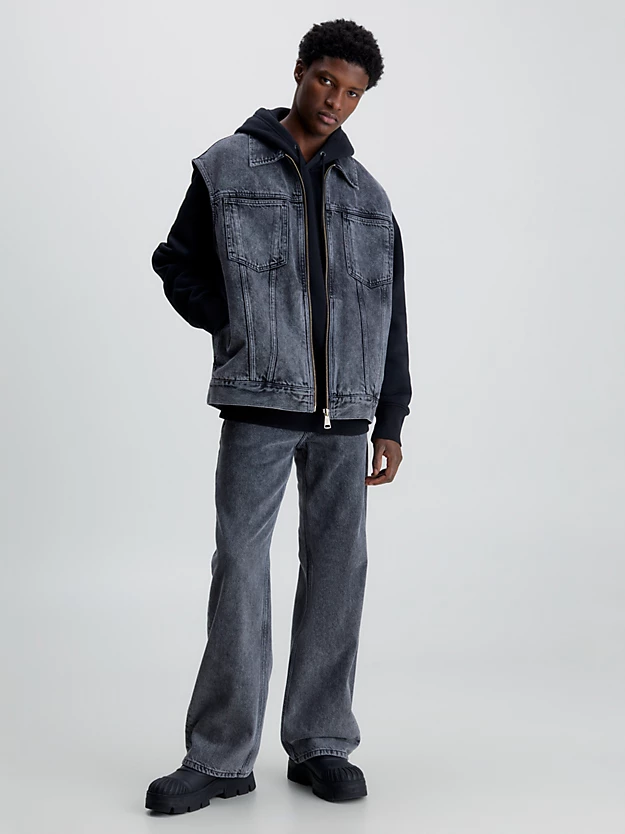 Colete jeans oversized com zíper frontal completo.