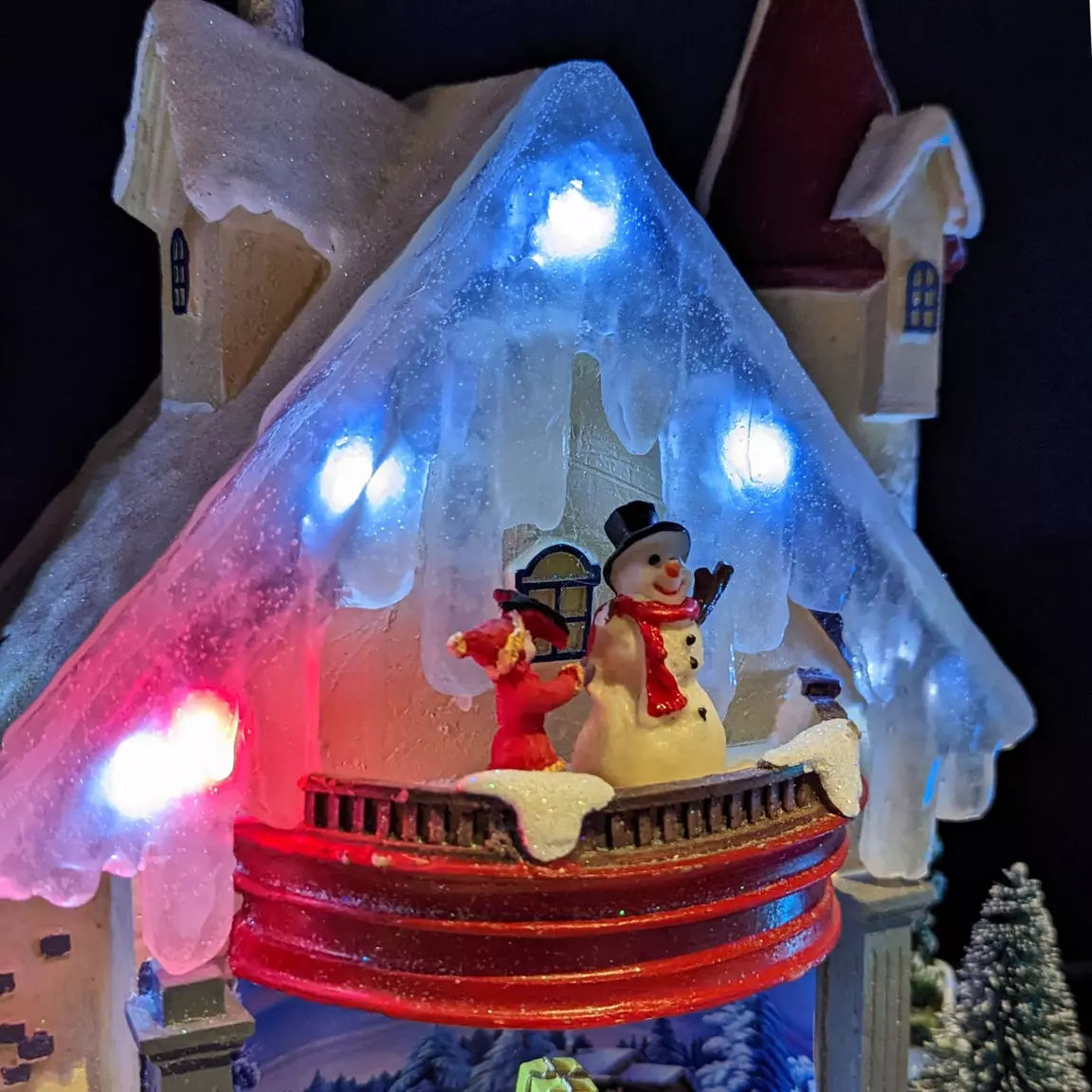 Maison du bonhomme de neige enneigée et illuminée à piles