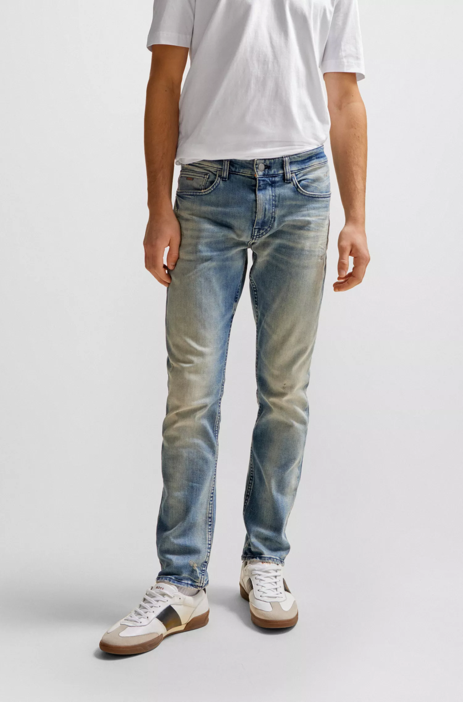Calça jeans BOSS laranja, corte slim, em denim azul com tonalidade bege.