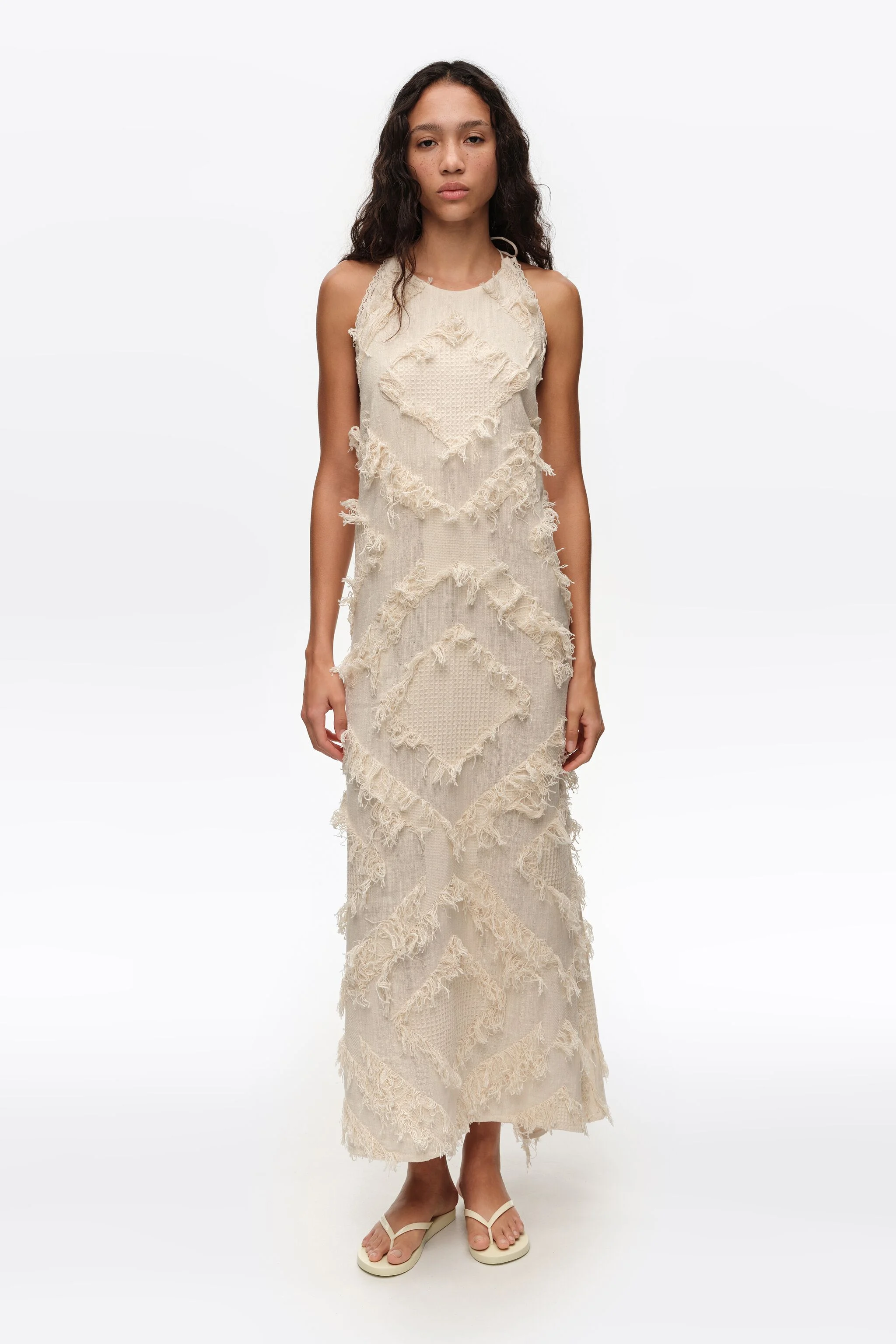 Vestido marfim com decote halter e franjas.
