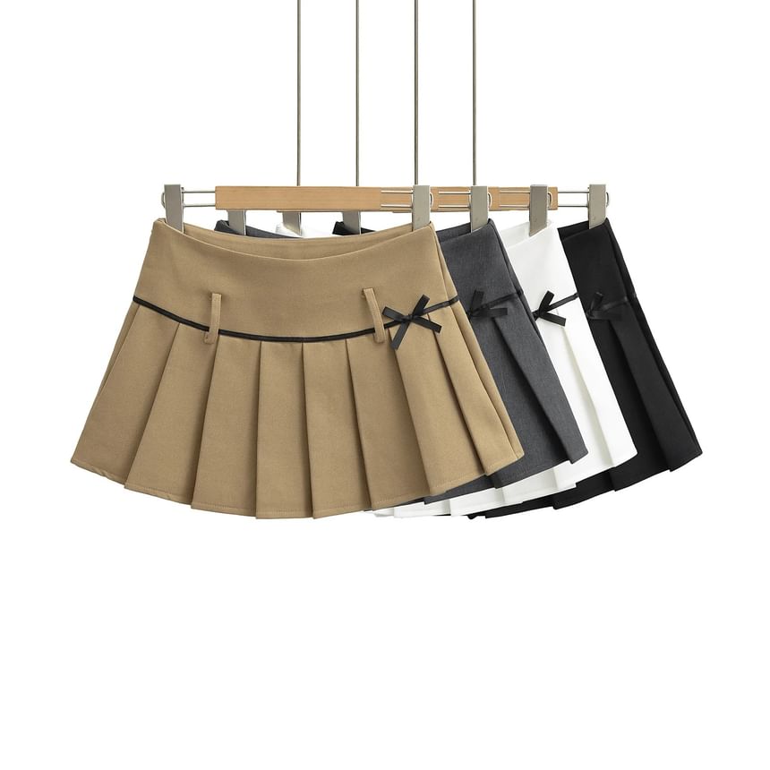 Asiris - Mini A-lijn geplooide rok met hoge taille en strikaccent