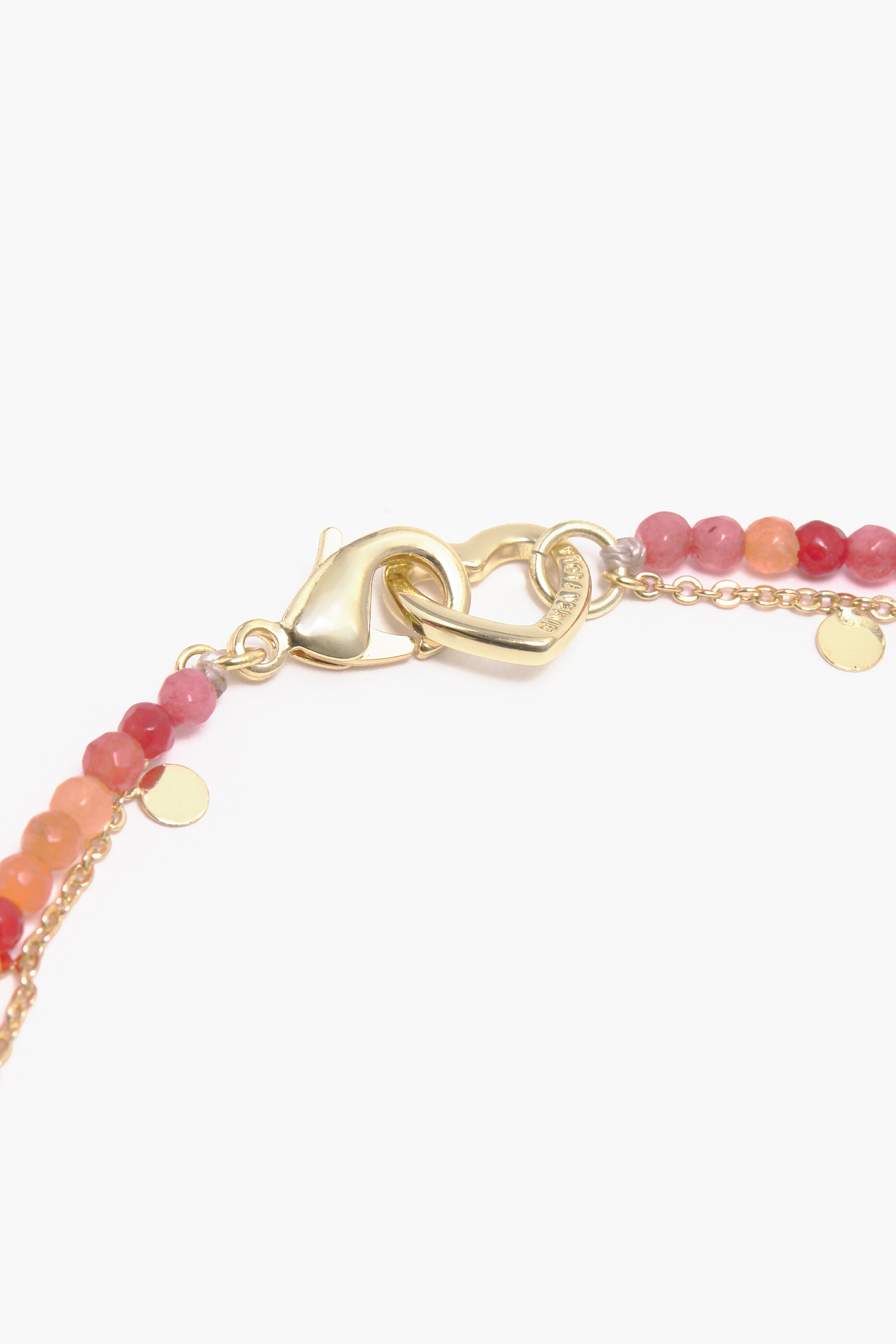 Colar curto com pingente de golfinho e pedras de coral.