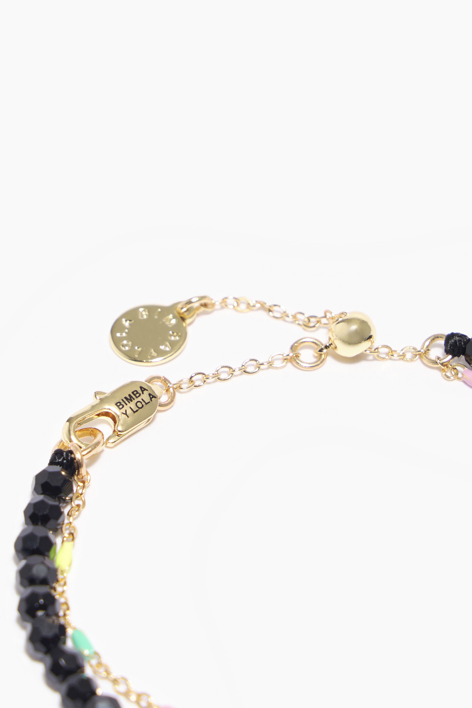 Pulseira com cristais facetados e corrente dourada.