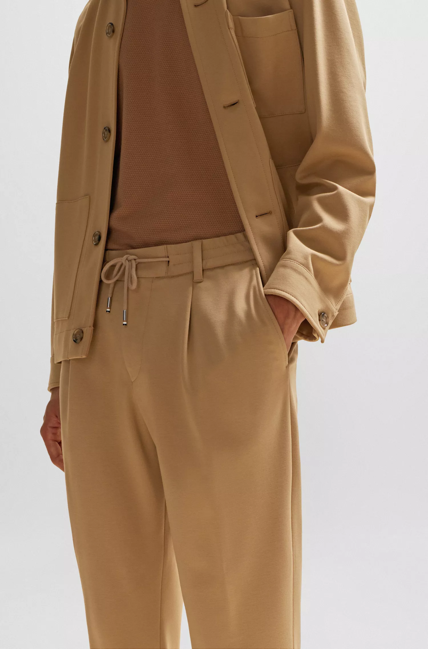 Calça BOSS preta, modelagem relaxada com cordão, em tecido bi-elástico.
