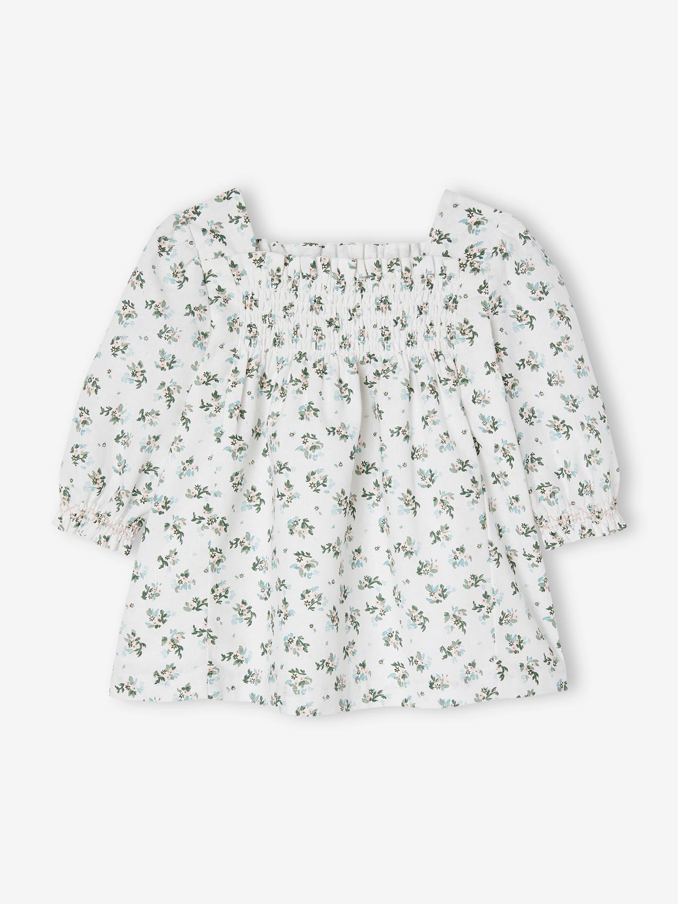 Vestido floral branco para bebê com detalhes franzidos.