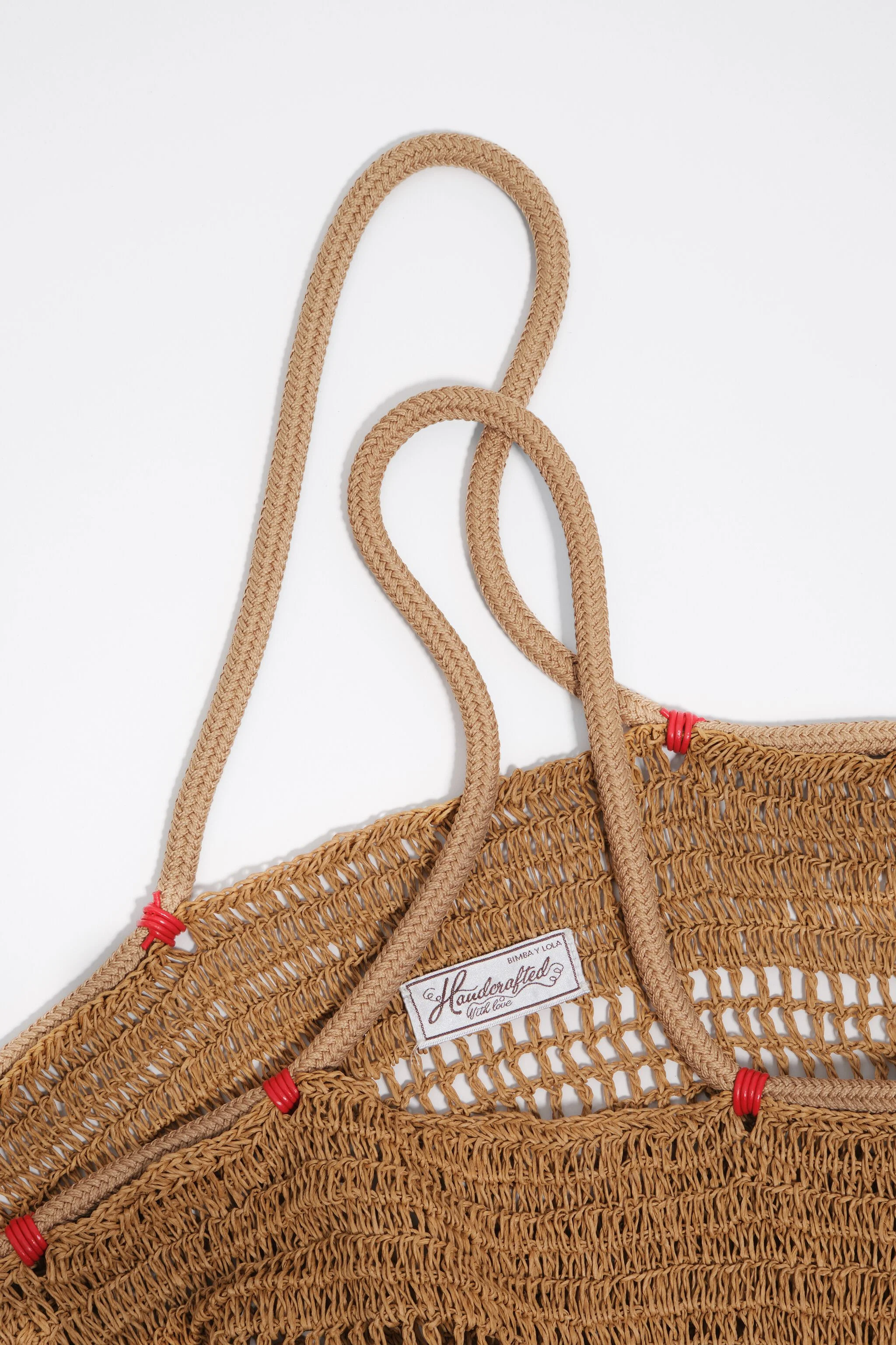 Bolsa de ombro grande em tom escuro natural com efeito ráfia.